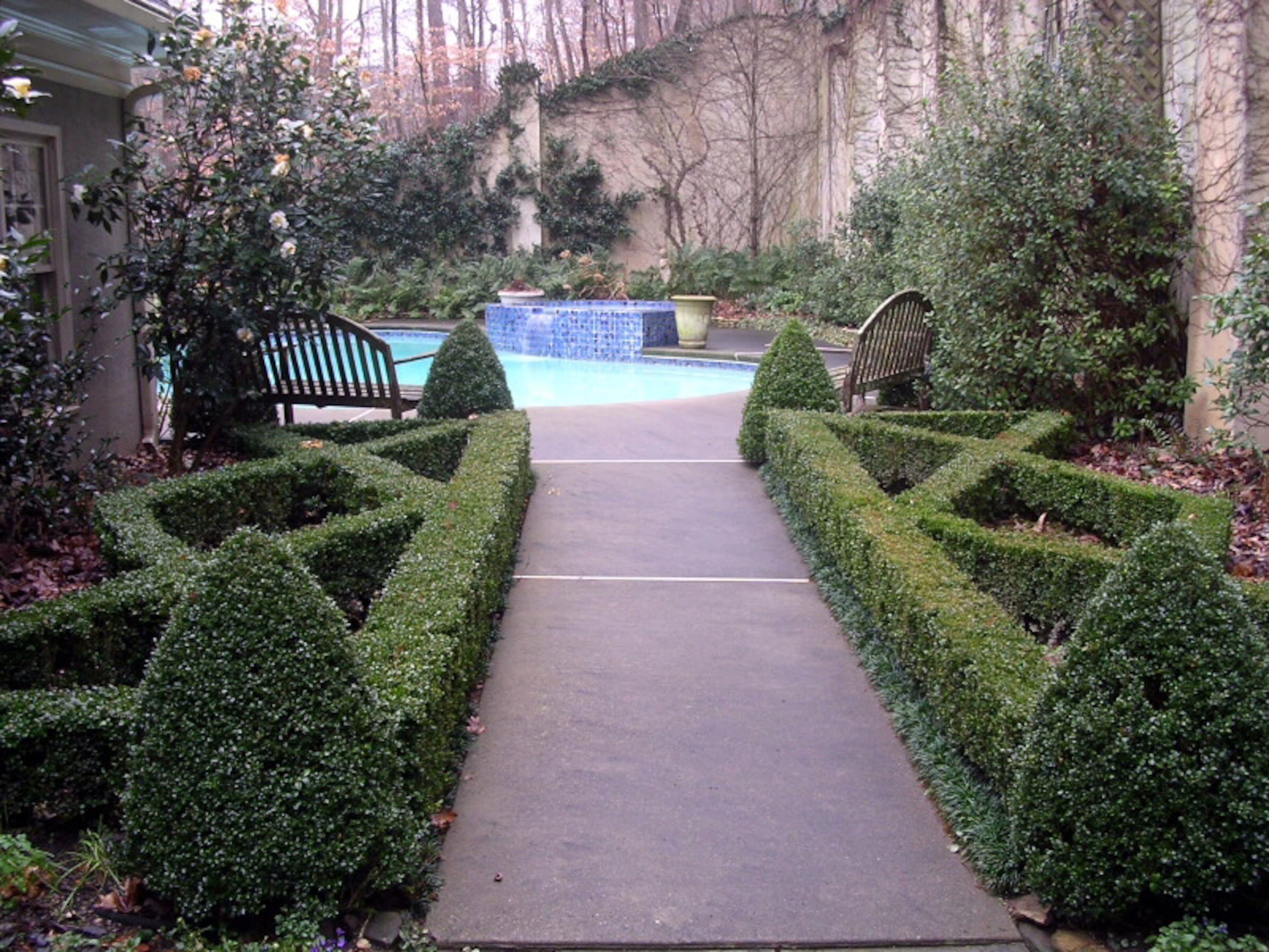 A beautiful rock wall, a raised fishpond, and a hidden woodland garden along a natural stream were part of the home.