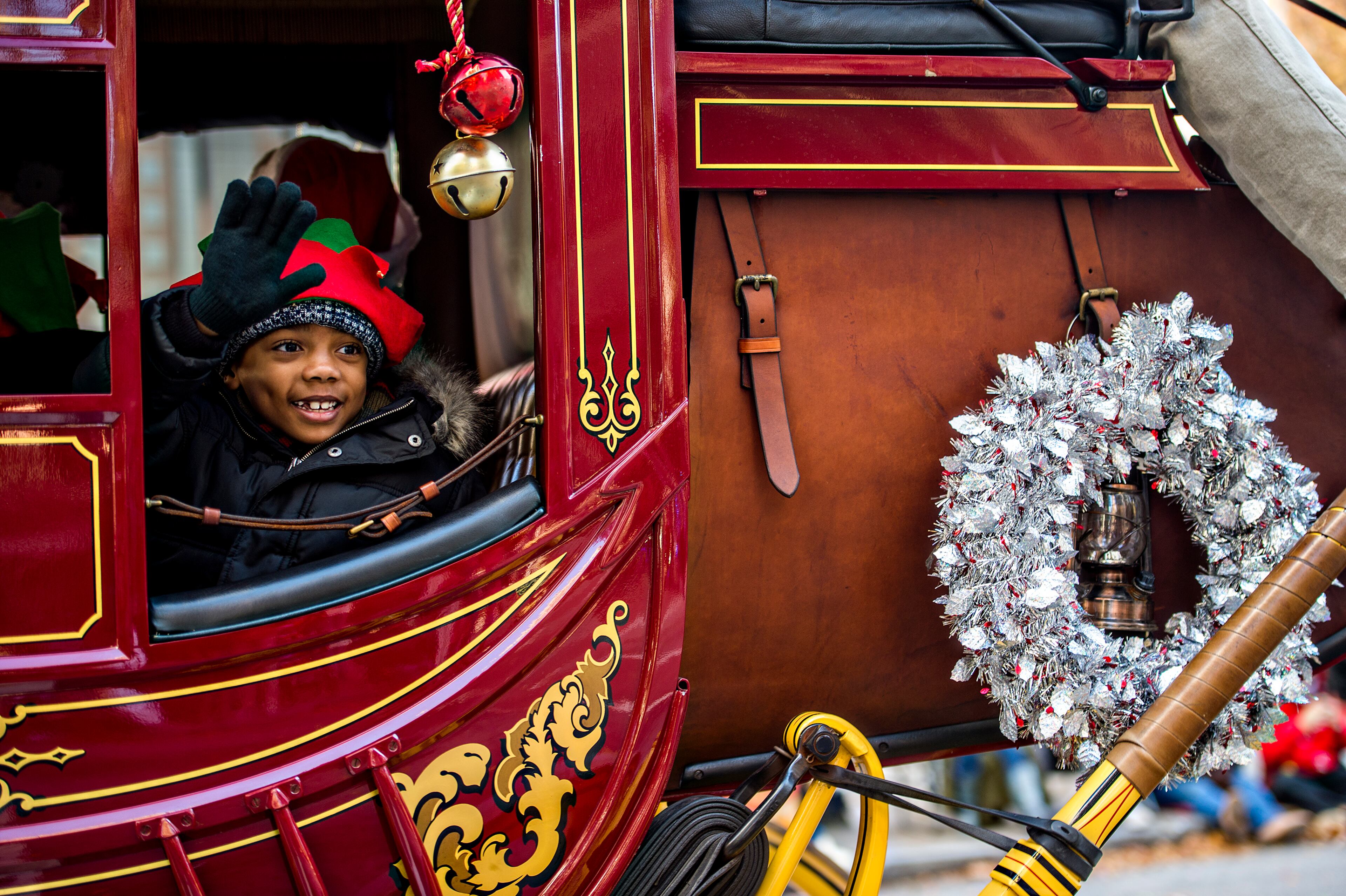 December 5, 2015 Atlanta - Donovan Lawson waves to the crowd as he rides in a stagecoach during the 2015 Children's Christmas Parade in Atlanta on Saturday, December 5, 2015. Thousands gathered along Peachtree St. to watch the parade pass with marching bands, balloons, performances and more. JONATHAN PHILLIPS / SPECIAL