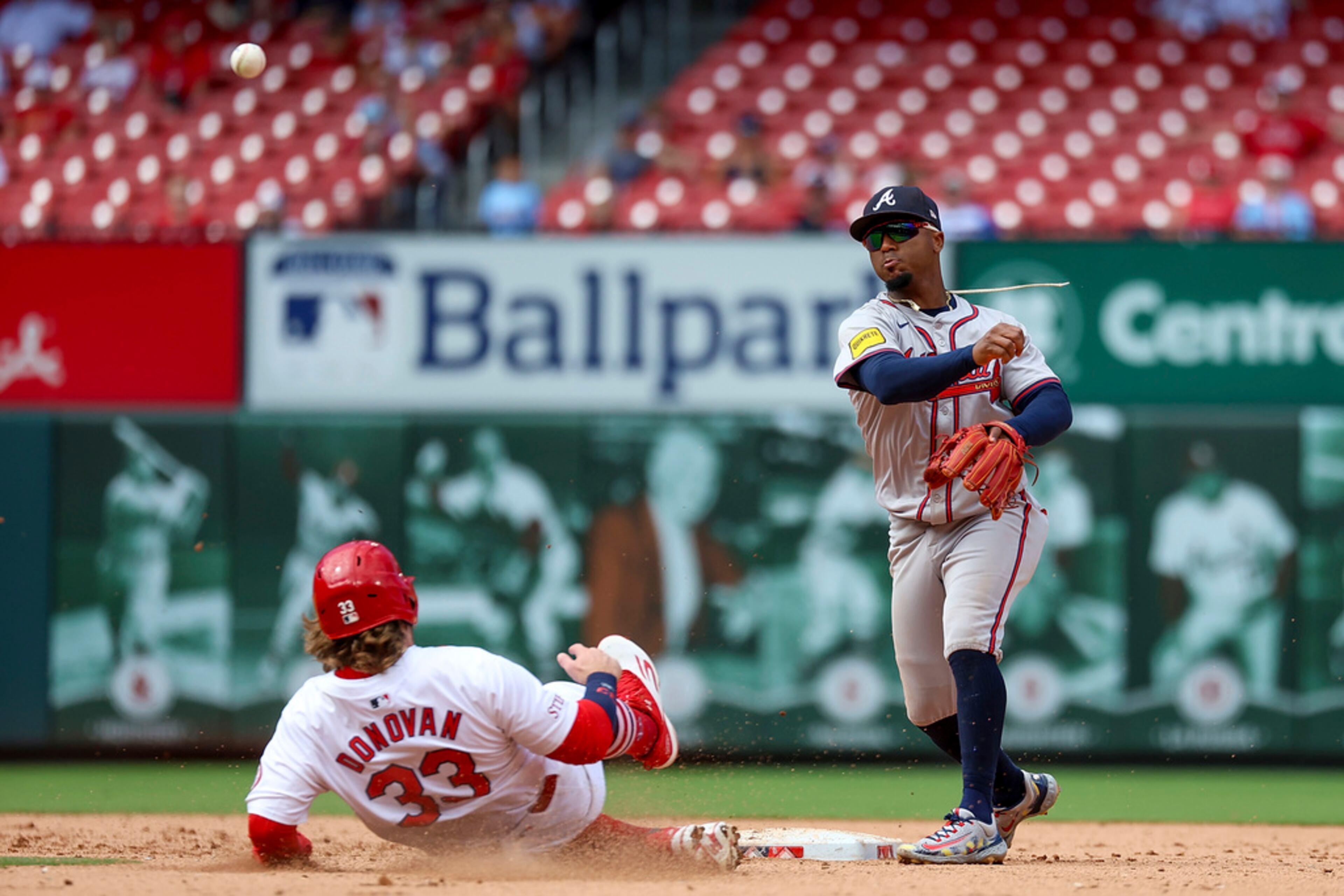 Atlanta Braves second baseman Ozzie Albies turns a double play over St. Louis Cardinals' Brendan Donovan during the eighth inning in the first game of a baseball doubleheader Wednesday, June 26, 2024, in St. Louis. (AP Photo/Scott Kane)