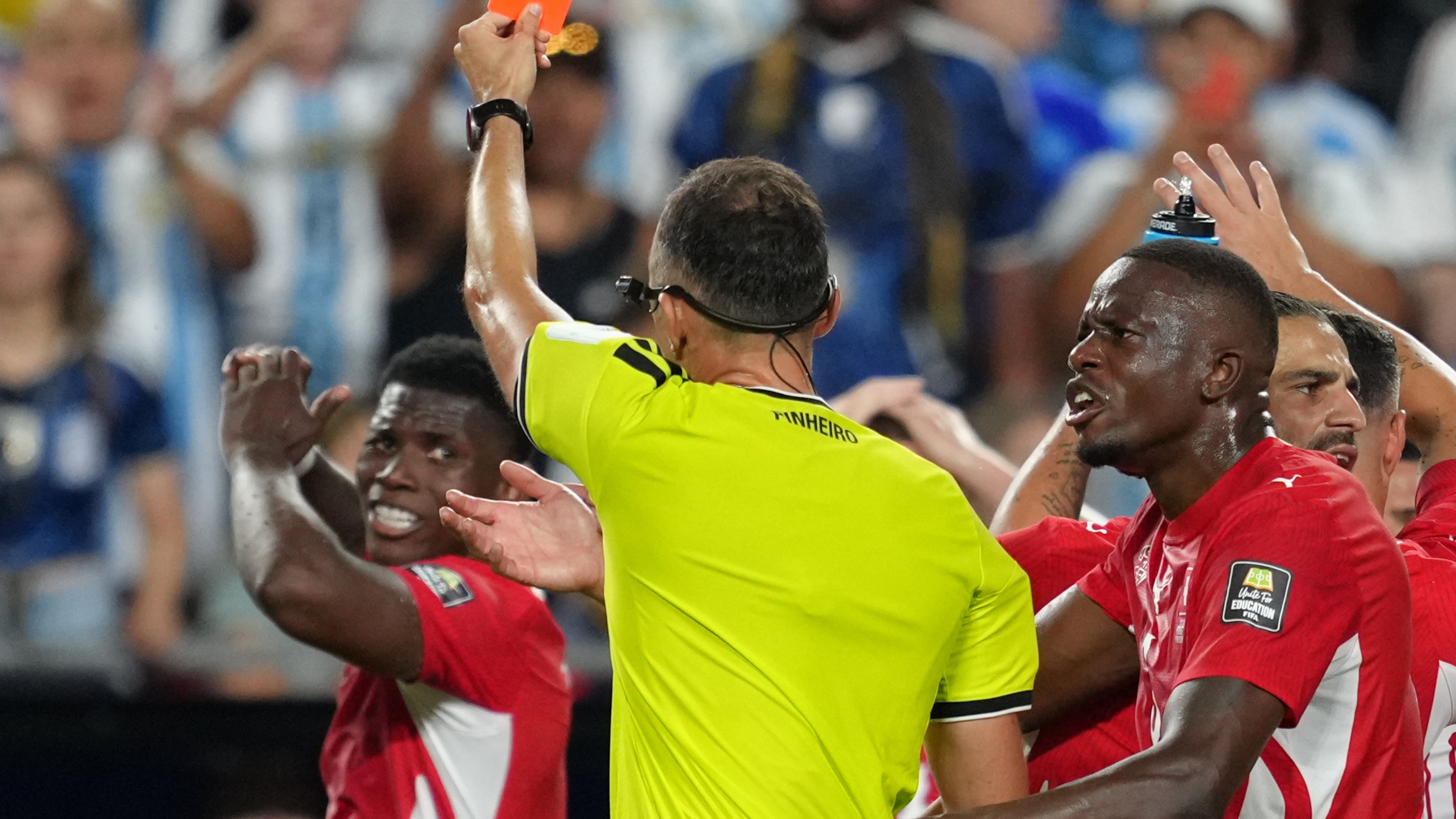 Referee Joao Pinheiro, of Portugal, gives a red card to Switzerland's Breel Embolo (7), left, during the World Cup quarterfinal soccer match between Argentina and Switzerland in Kansas City, Mo., Saturday, July 11, 2026. (AP Photo/Ed Zurga)
