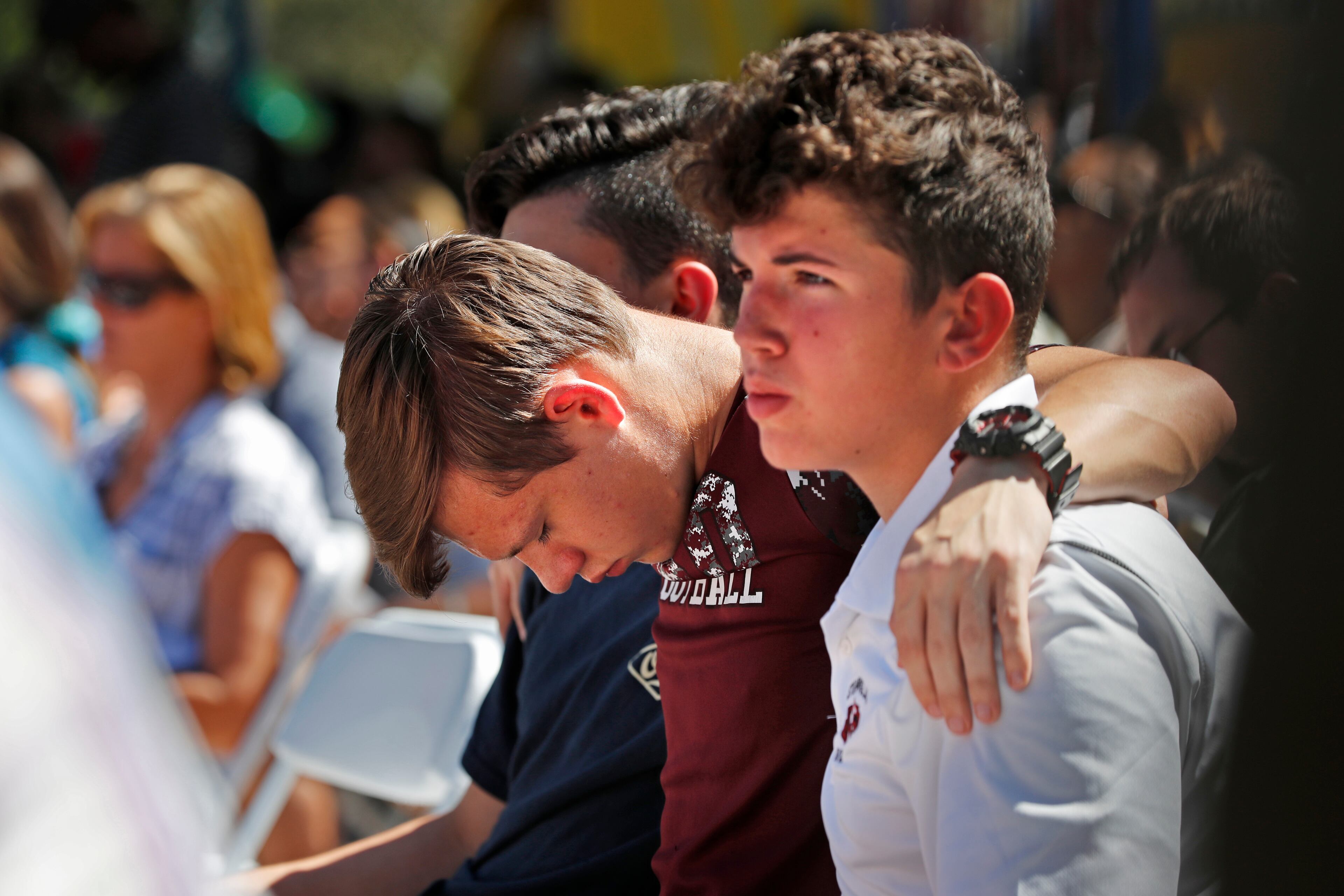 Ryan Schroy, 15, center, bows his head in prayer as he embraces Dylan O'Neill, 15, right, both students at Marjory Stoneman Douglas High School, during a vigil at the Parkland Baptist Church, for the victims of the Wednesday shooting at the high school, in Parkland, Fla., Thursday, Feb. 15, 2018. Nikolas Cruz, a former student, was charged with 17 counts of premeditated murder on Thursday. (AP Photo/Gerald Herbert)