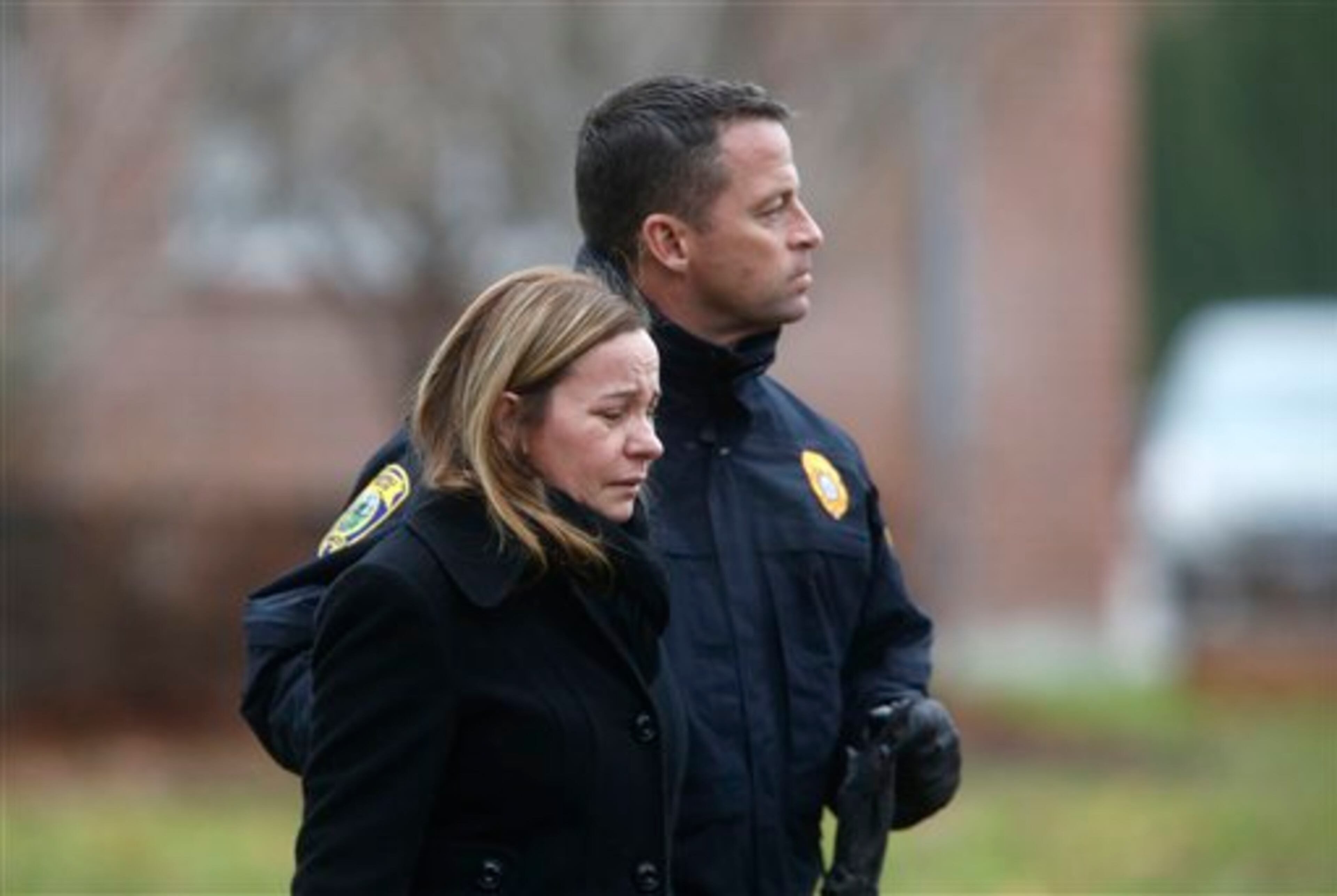 A mourner is comforted by a police officer as she arrives at a funeral service for 6-year-old Noah Pozner, Monday, Dec. 17, 2012, in Fairfield, Conn. Pozner was killed when a gunman walked into Sandy Hook Elementary School in Newtown Friday and opened fire, killing 26 people, including 20 children. (AP Photo/Jason DeCrow)