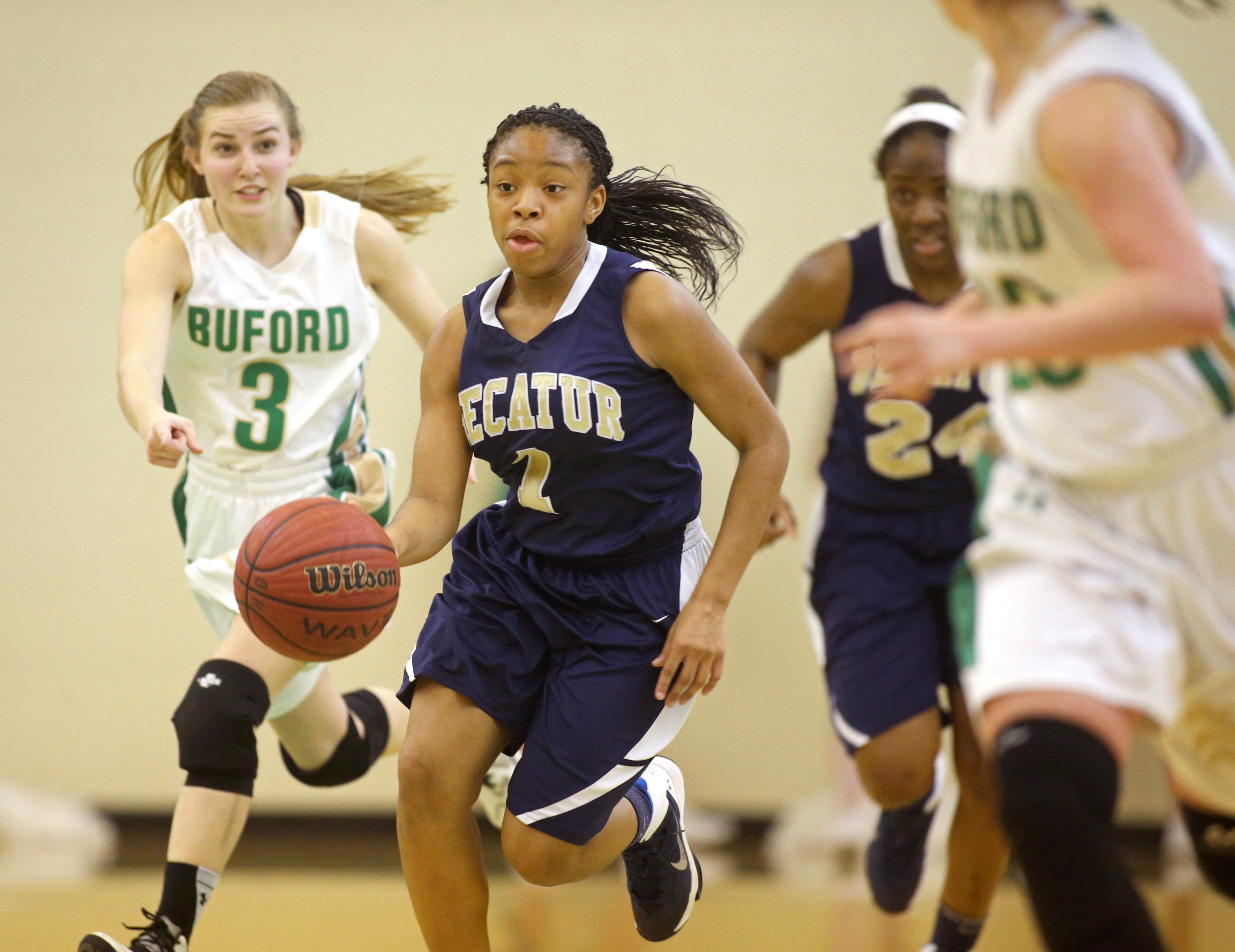 Decatur's Jayla Morrow (1) drives through Buford defenders Monday night. Buford defeated Decatur 41-28 in the second round of the Class AAA state basketball tournament. Morrow led Decatur in scoring with 15 points. JASON GETZ / SPECIAL