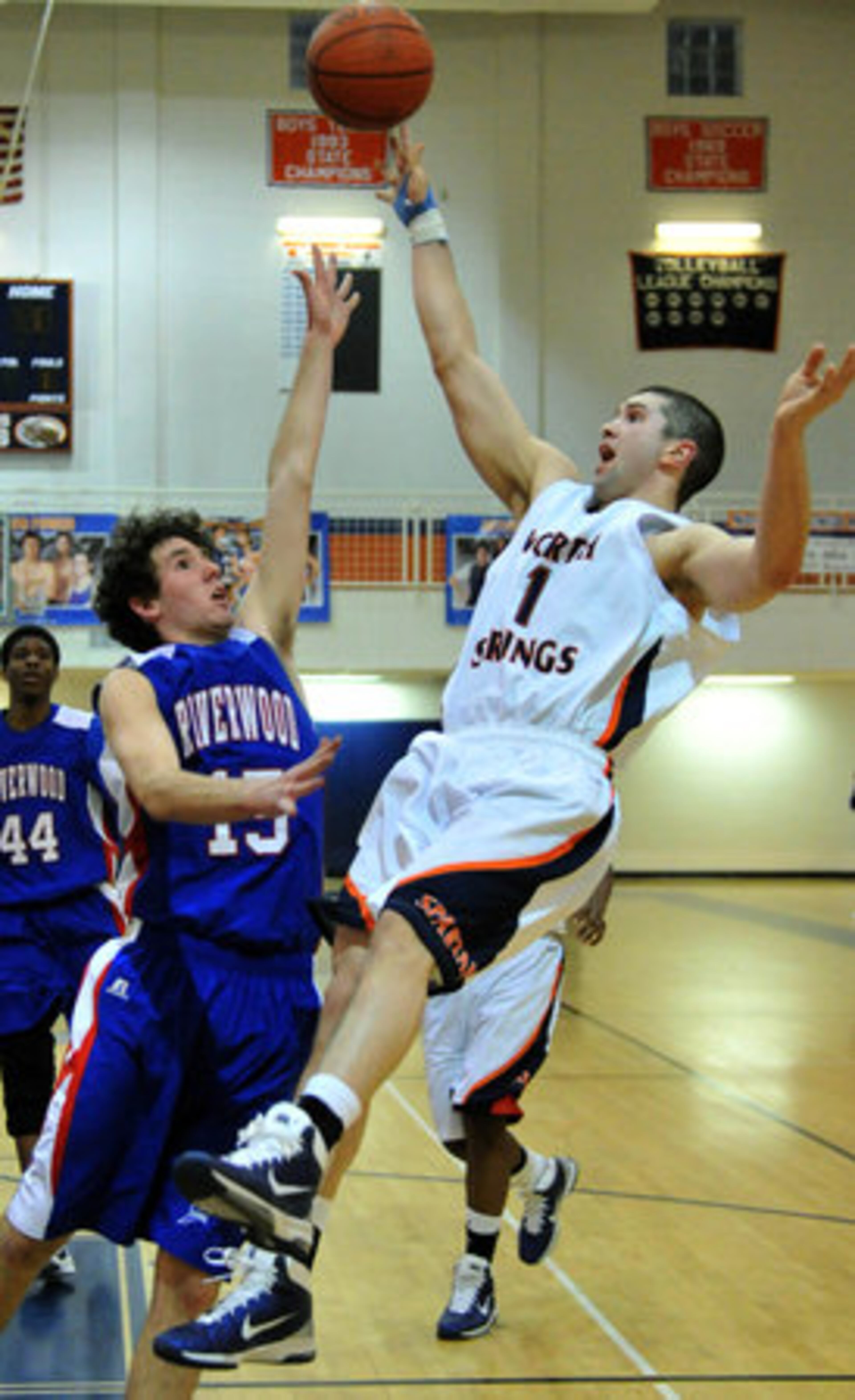 North Springs' John Burke (1) shoots against Riverwood's Ben Davis (15) as he falls backward during the second half at North Springs High School in Sandy Springs on Tuesday, Feb. 8, 2011. Riverwood won 73 - 67 over North Springs.