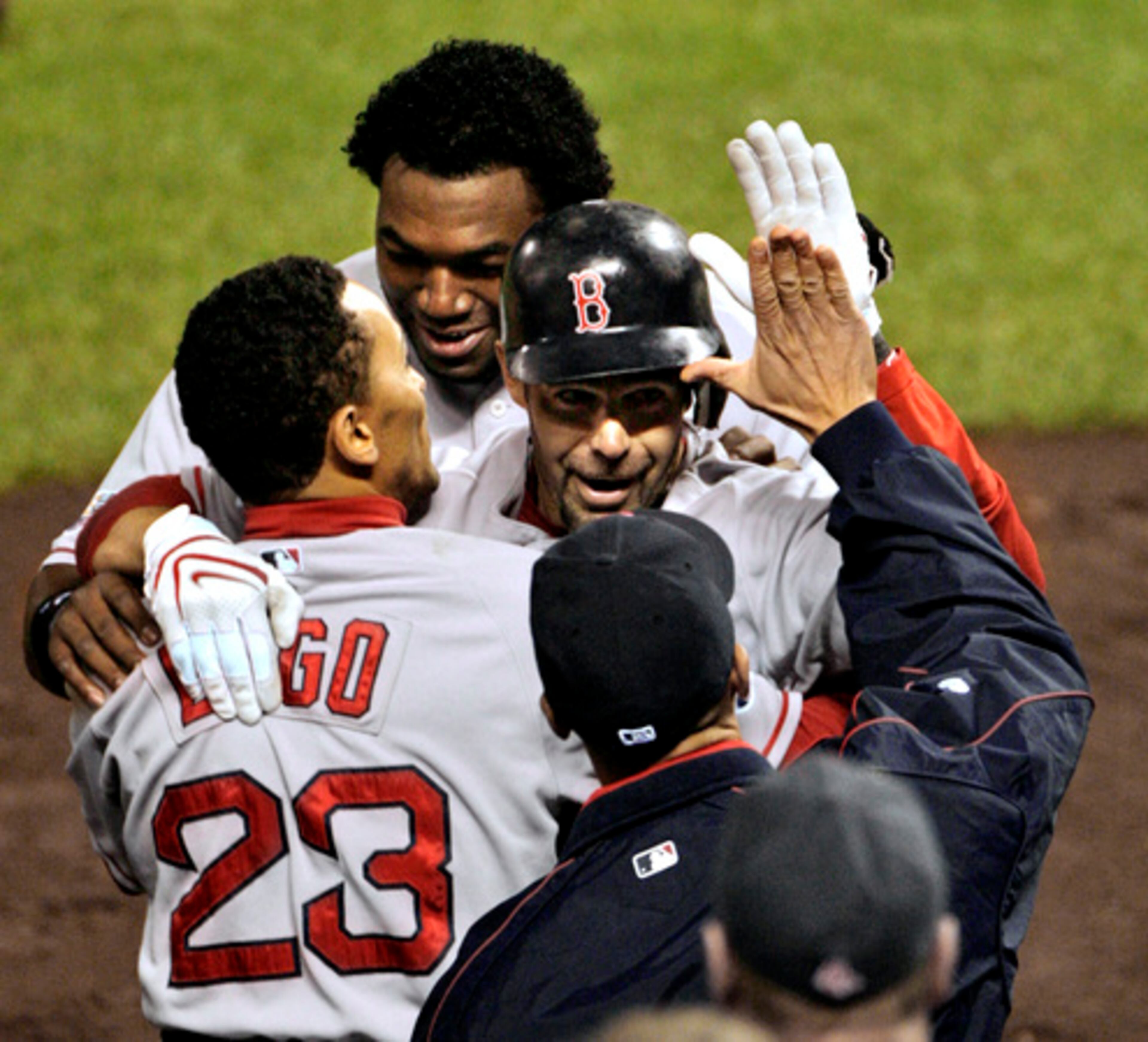 Boston Red Sox's Mike Lowell, center, is greeted by teammates Julio Lugo (23) and David Ortiz, back, after Lowell's seventh inning home run in Game 4.
