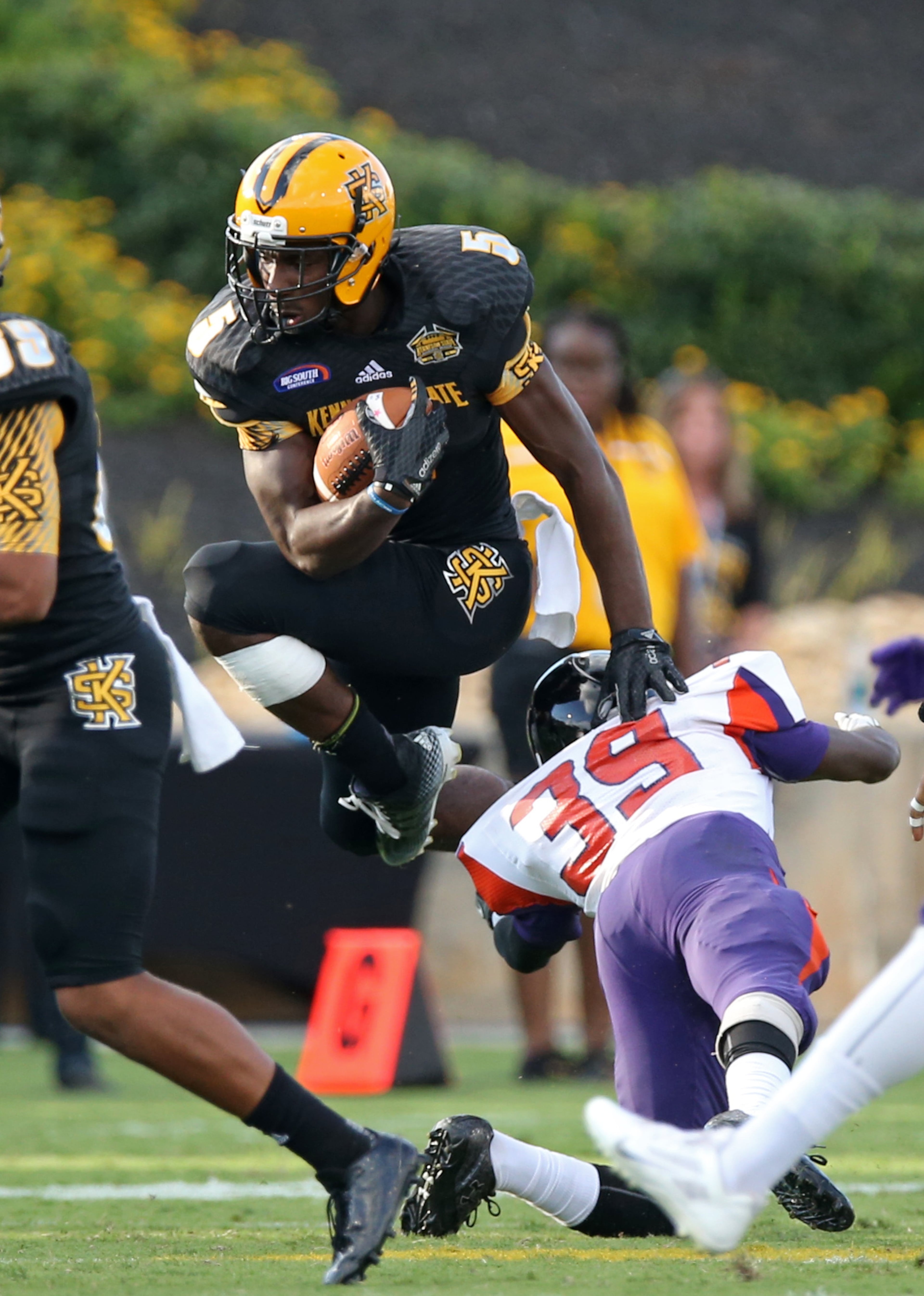 September 12, 2015 - Kennesaw, Ga: Kennesaw State University running back PJ Stone (5) jumps over Edward Waters defensive back Jonathan Moreland (39) on a kickoff return in the fourth quarter of their game at Fifth Third Bank Stadium, Saturday, September 12, 2015, in Kennesaw, Ga.. KSU won 58-7. This is the first home game of KSU's inaugural football season. PHOTO / JASON GETZ