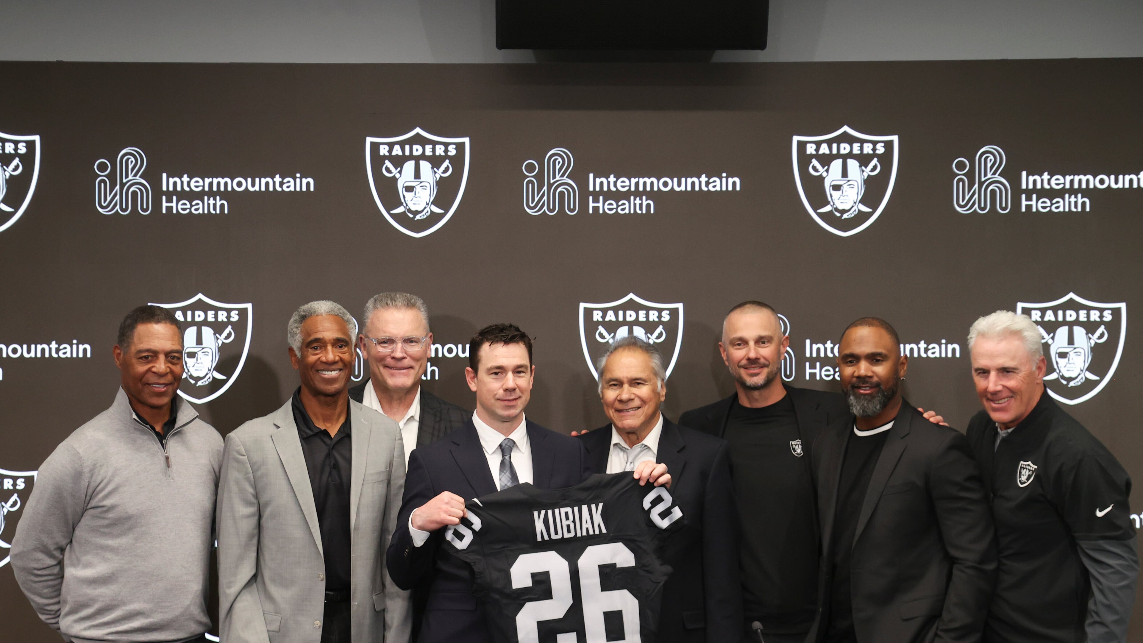 Las Vegas Raiders new head coach Klint Kubiak, fourth from left, poses with from left, Marcus Allen, Mike Haynes, Howie Long, Jim Plunkett, general manager John Spytek and Charles Woodson during an introductory news conference at the NFL football team's training facility Tuesday, Feb. 10, 2026, in Henderson, Nev. (AP Photo/Ian Maule)
