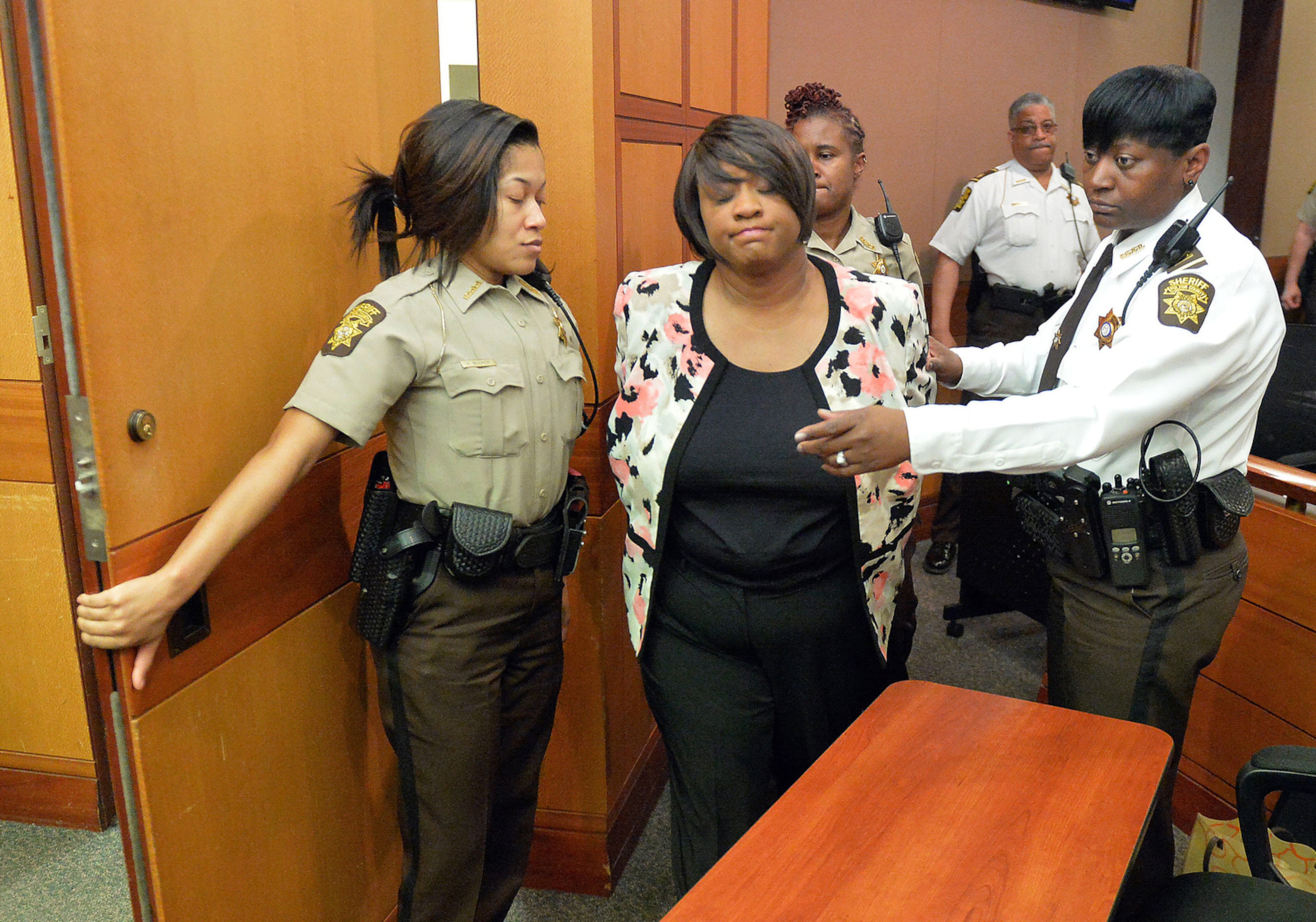 Former Atlanta Public Schools school reform team director Tamara Cotman, center, is led to a holding cell after a jury found her guilty in the Atlanta Public Schools test-cheating trial. Cotman was one of 11 educators convicted in the case and another 21 pleaded guilty. (AP Photo/Atlanta Journal-Constitution, Kent D. Johnson, Pool)