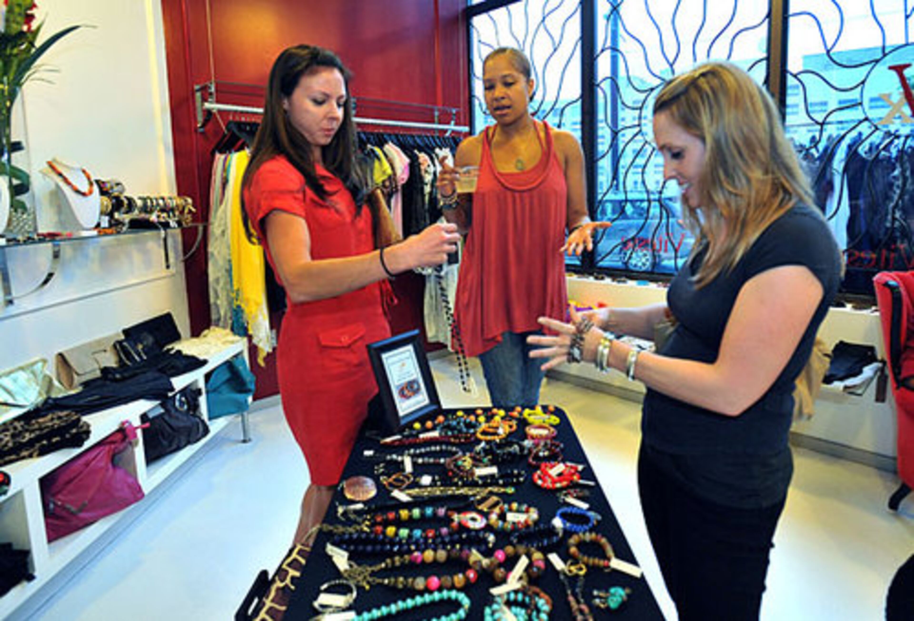 Alondeia Chaney (center), jewelry designer, helps customers Chrissy Wild (left), 28, of Midtown, and Kelly Petrello (right), 31, of Inman Park, during the 2nd Friday Art Stroll at Vitesse eXchange in Castleberry Hill on Friday, April 8, 2011