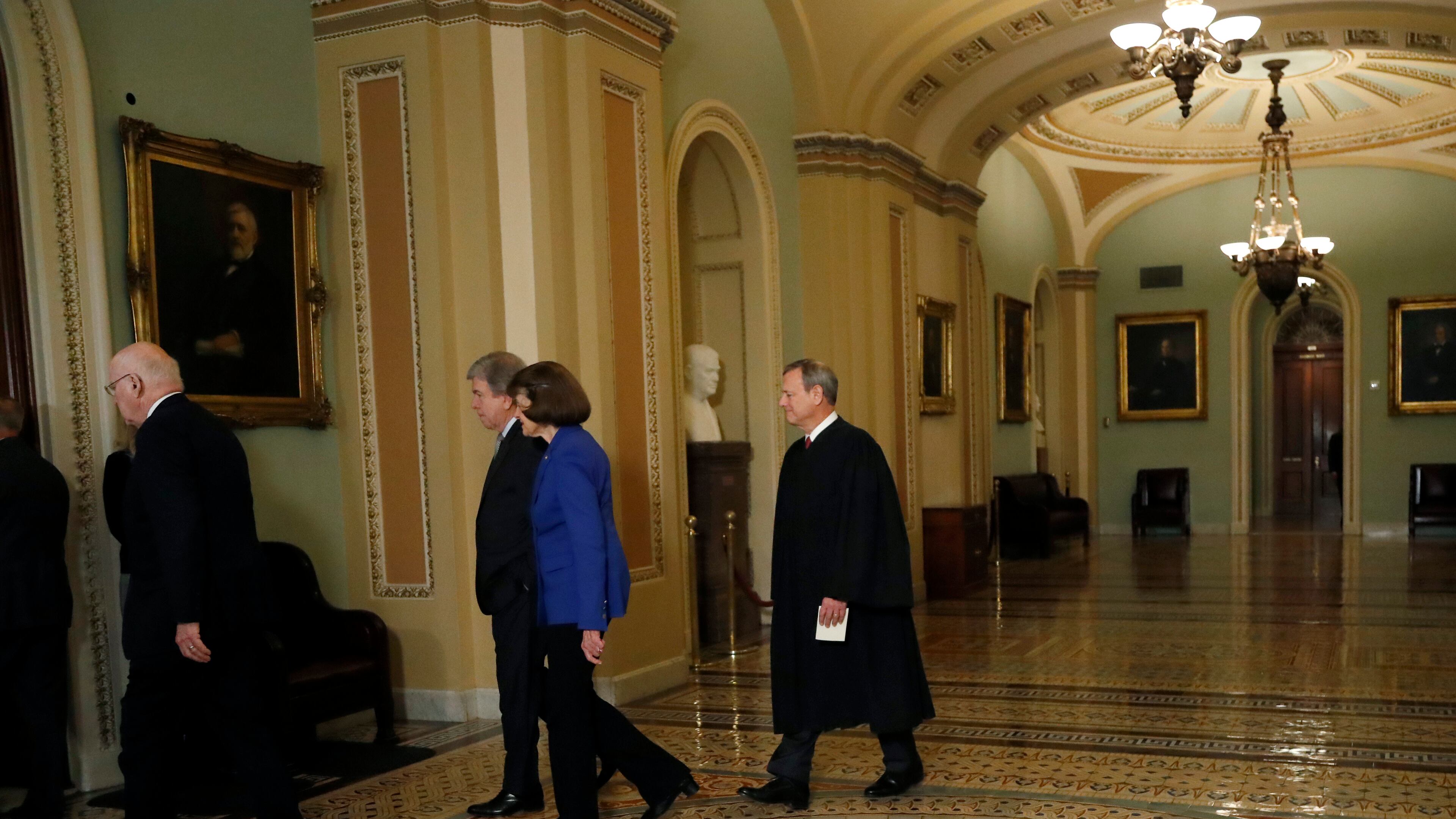 Chief Justice of the United States John Roberts, right, walks to the Senate chamber at the Capitol in Washington, Thursday, Jan. 16, 2020. (AP Photo/Julio Cortez)