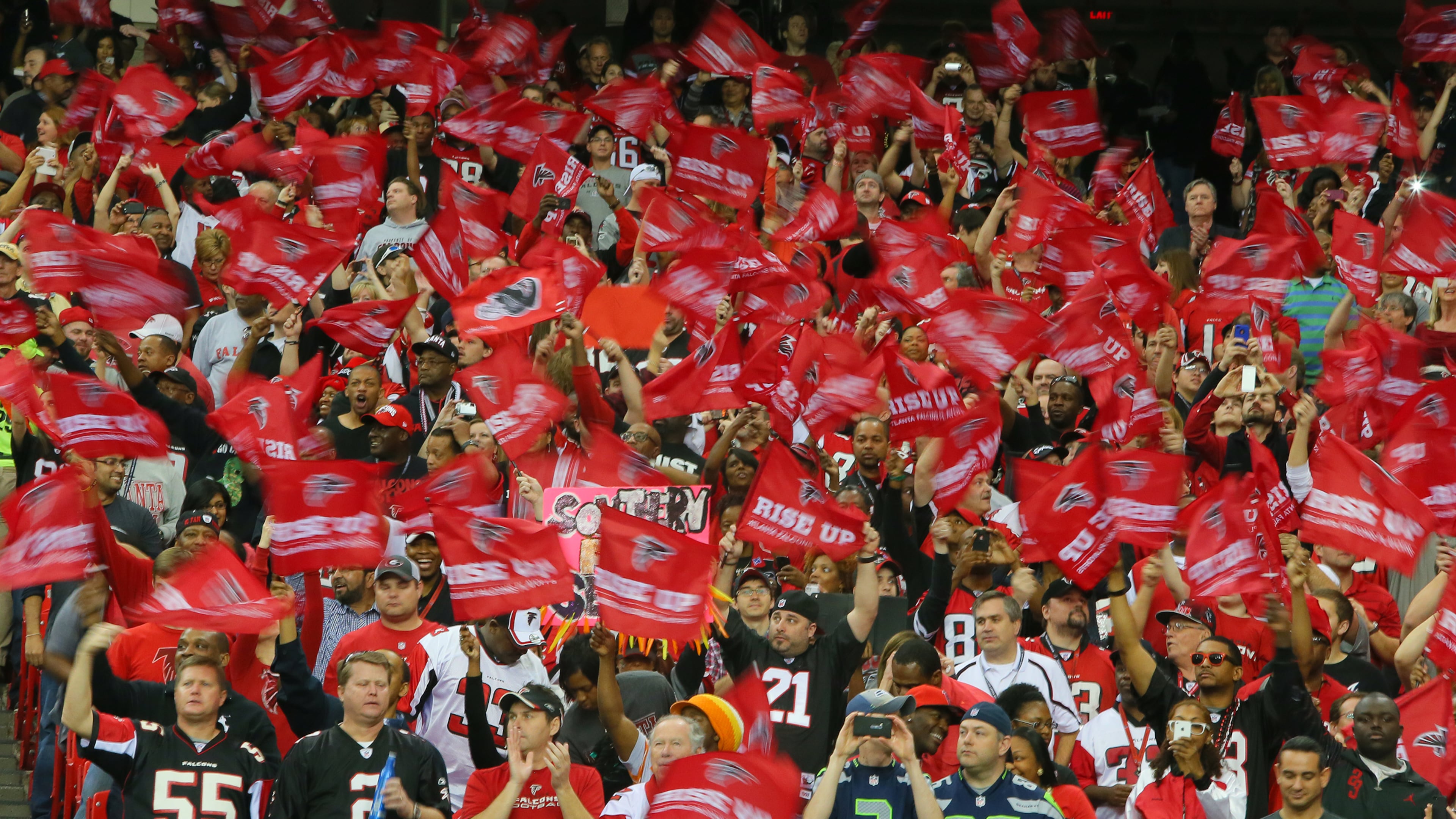 Falcons fans wave "Rise Up" flags in a frenzy during the first quarter of their playoff game against the Seahawks on Jan. 13, 2013.