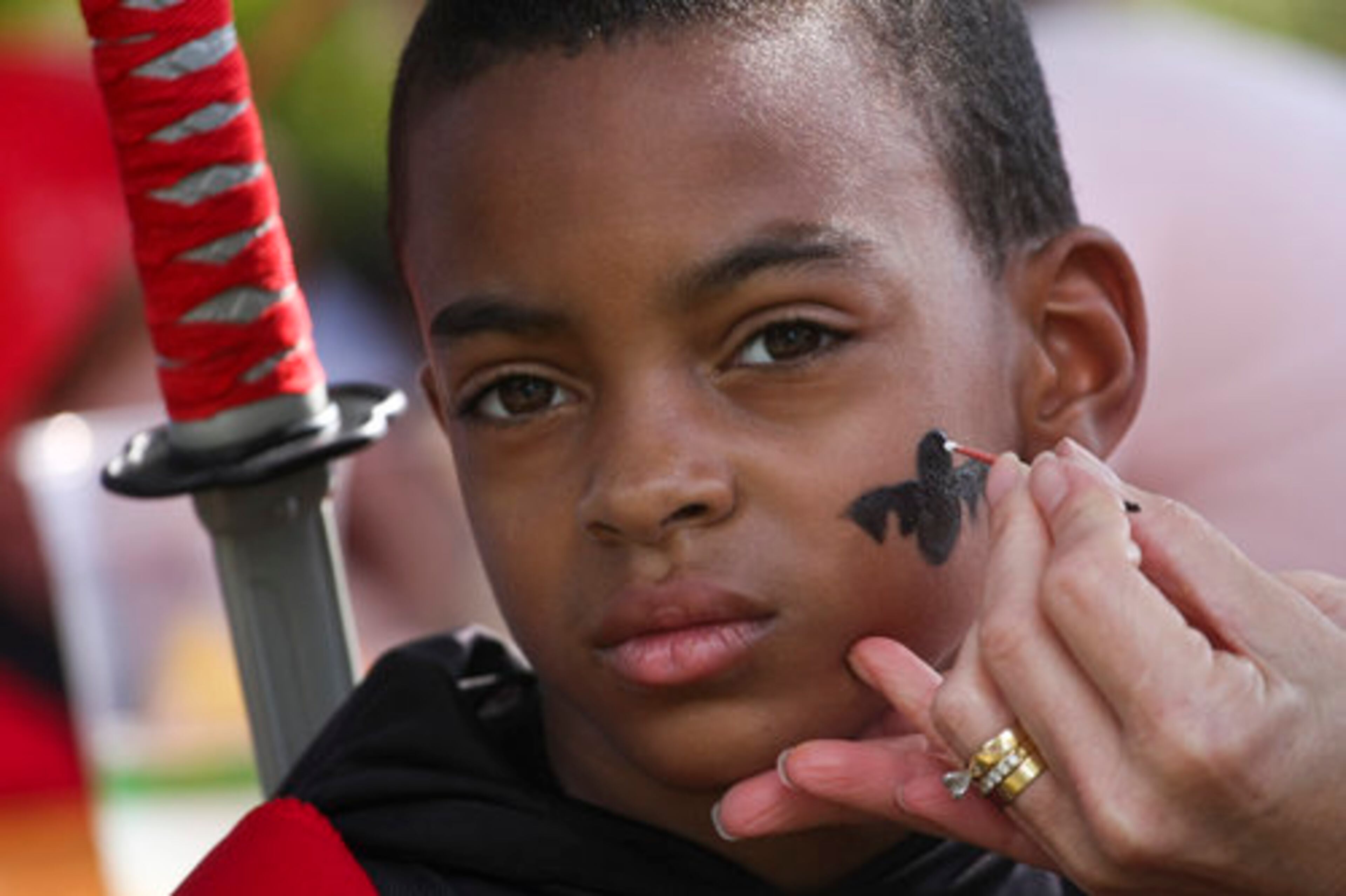 Seven-year-old Javoreus Mapp of Madison has a batman symbol painted on the side of his cheek during Atlanta Botanical Garden's annual Goblins in the Garden, Sunday, October 24, 2010.