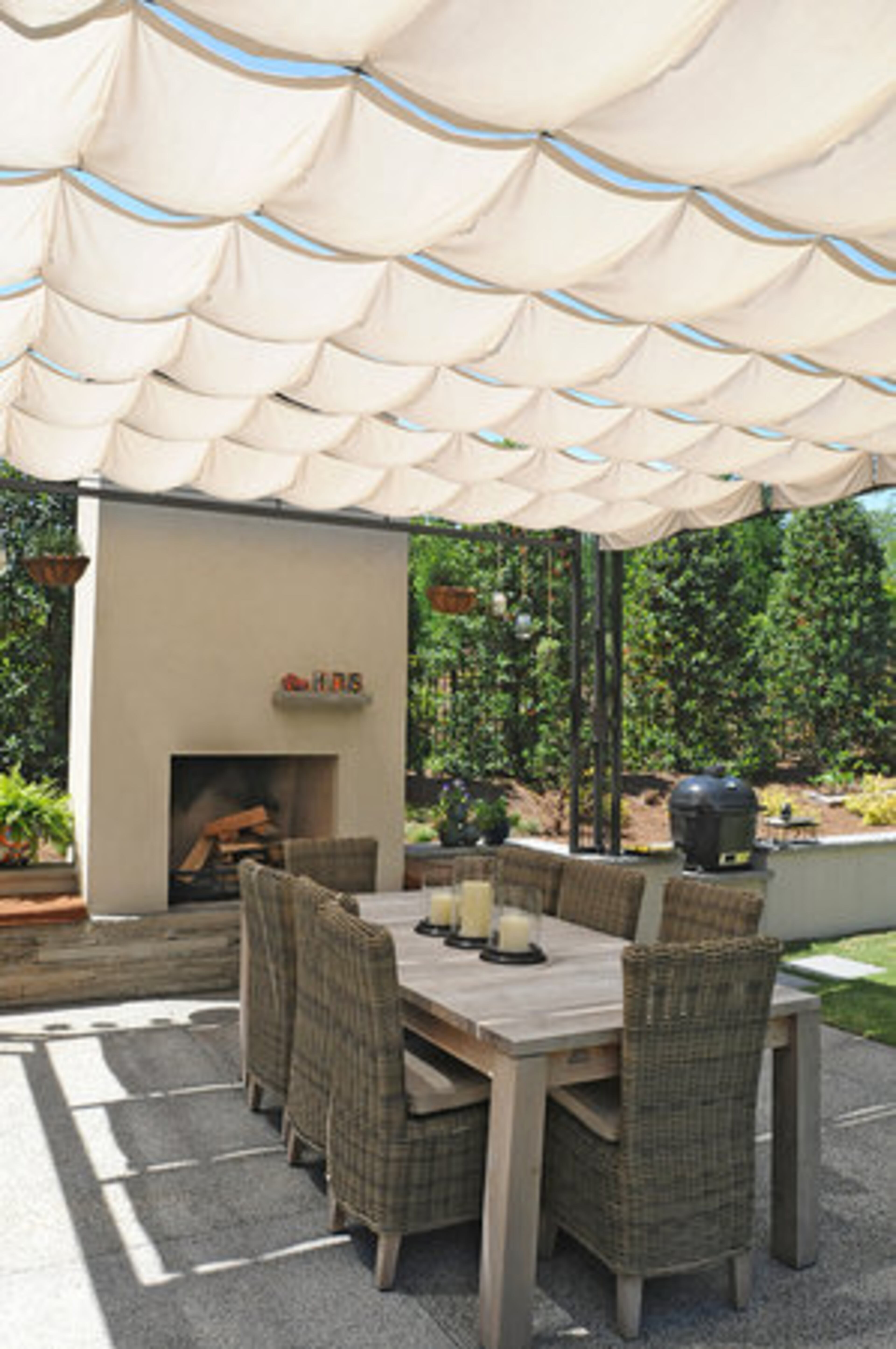 The reclaimed teak farm table under the covered pergola sits next to an outdoor fireplace and Evelyn's potted herb garden. It also functions as the main dining area during the warmer months. Evelyn grows year round seasonal organic vegetables in the backyard which she uses for the family and shares with her neighbors.