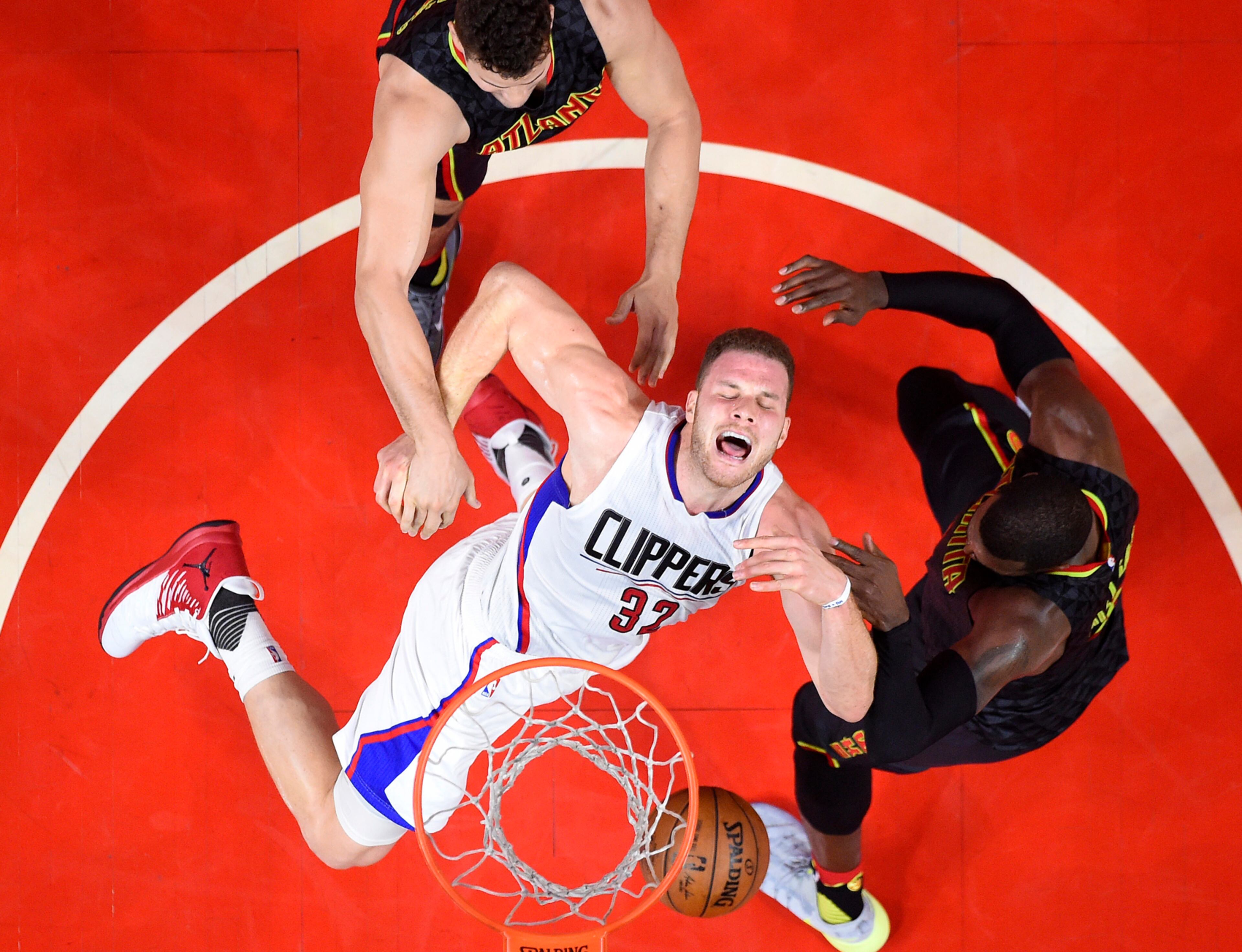 Los Angeles Clippers forward Blake Griffin, center, has the ball knocked out of his hands by Atlanta Hawks forward Paul Millsap, right, as forward Kris Humphries reaches in during the second half of an NBA basketball game, Wednesday, Feb. 15, 2017, in Los Angeles. The Clippers won 99-84. (AP Photo/Mark J. Terrill)