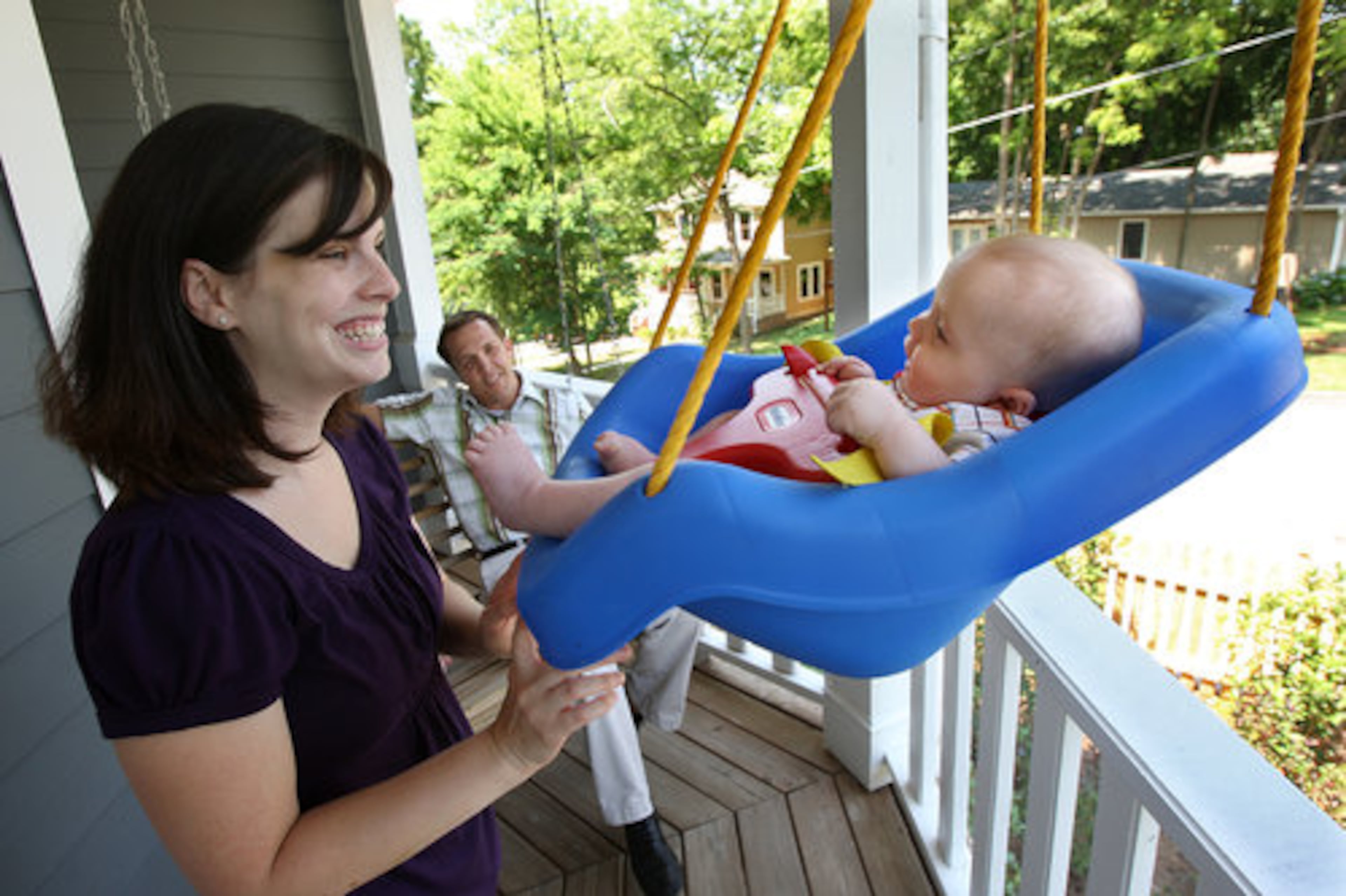 Brooke Eskew and 4-month old son Maddox enjoy the little tikes swing on the porch as husband, Shay, looks on.