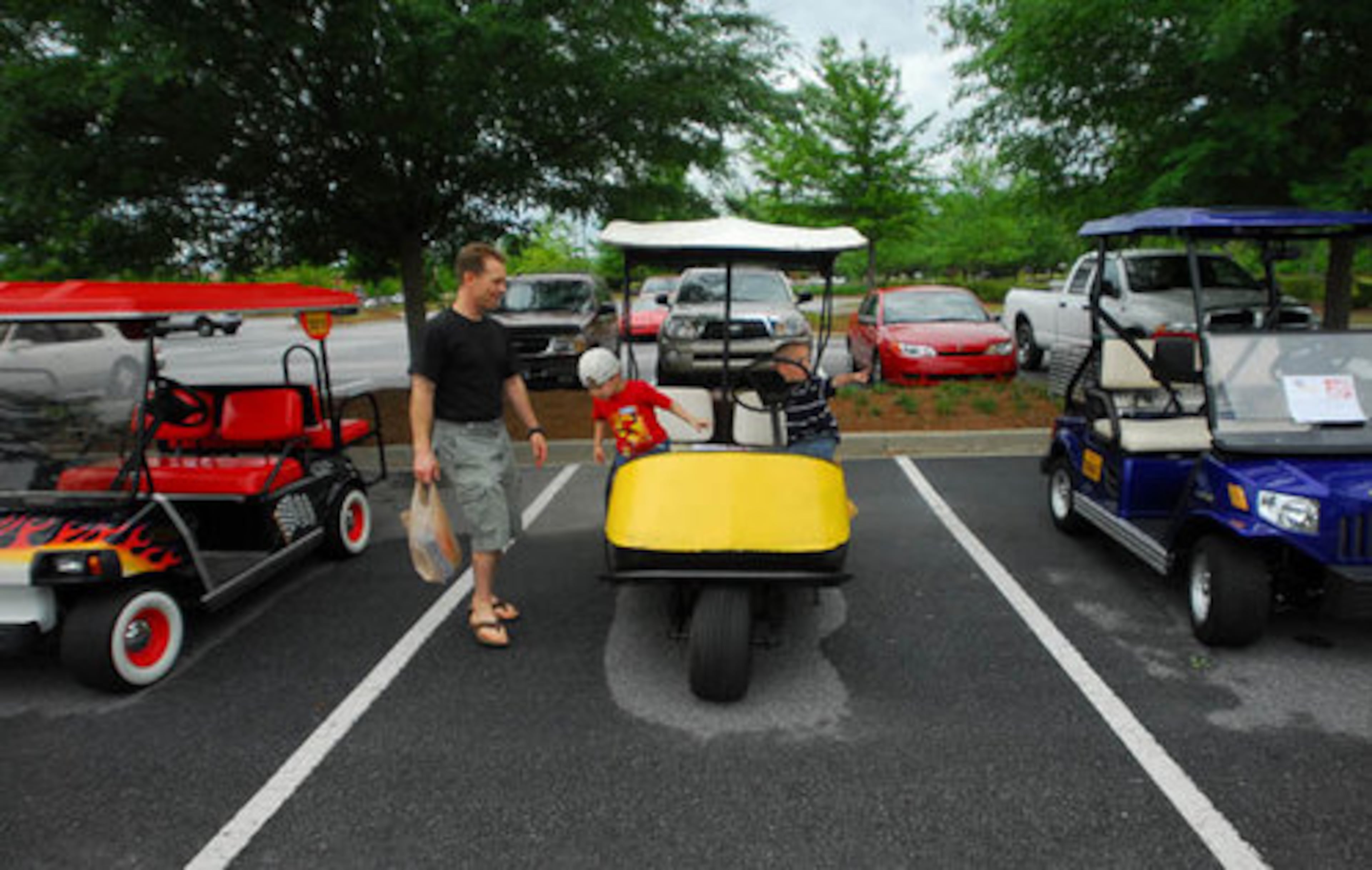 Chris Anderson, of Peachtree City, looks at an old 1967 Westinghouse Marketeer Golf Cart with his son Cody Anderson, 3, center, and Tyler Moorse, 3, during the 2008 Kiwanis Auto and Golf Cart Show in Peachtree City.