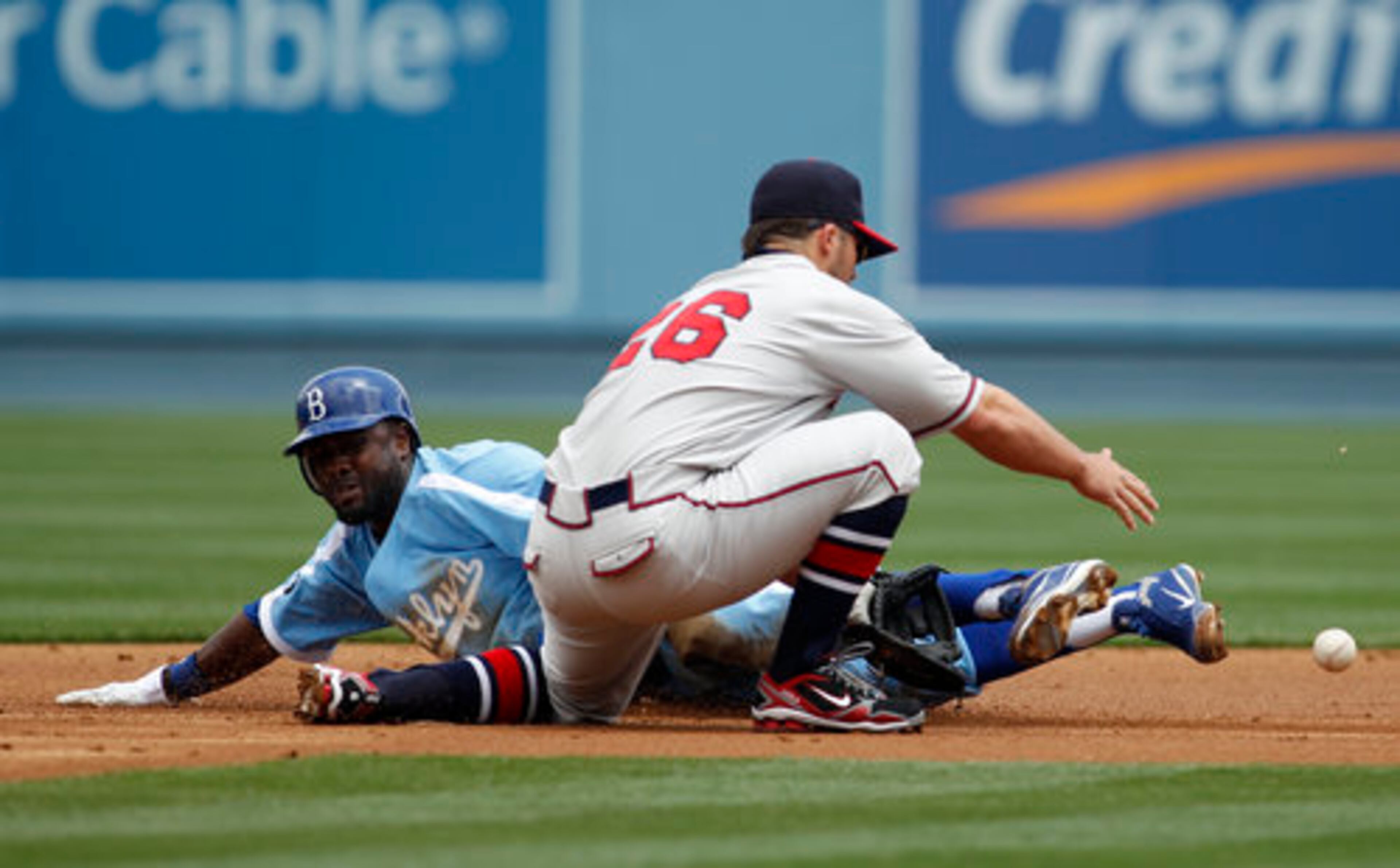 Los Angeles Dodgers' Tony Gwynn Jr., left, steals second base as Atlanta Braves' shortstop Dan Uggla, right, bobbles the ball during the first inning of a baseball game, Thursday, April 21, 2011, in Los Angeles.