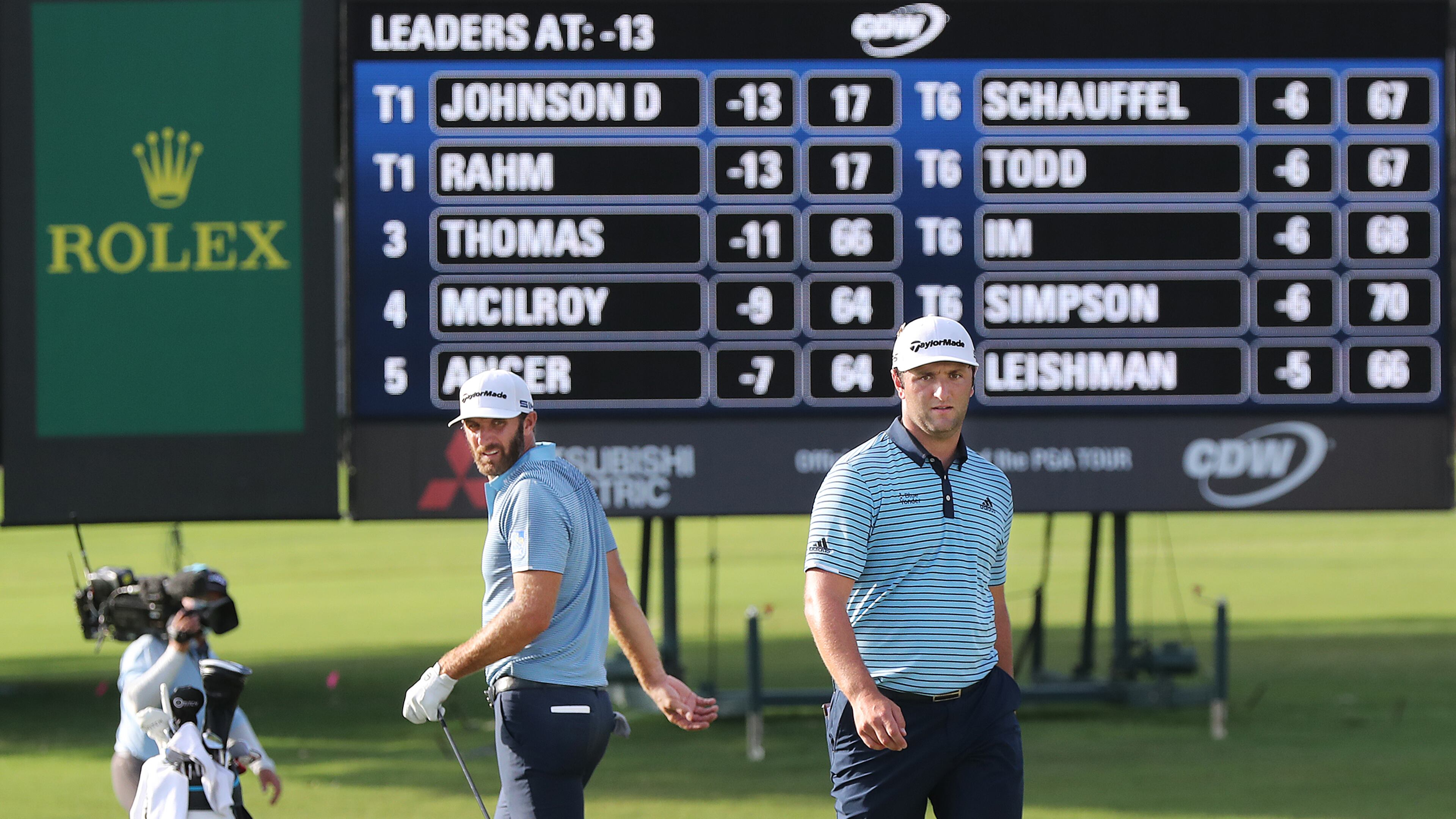 The leaders tied at 13 under par Dustin Johnson (left) and Jon Rahm (right) check out their shots on the 18th green during the first round of the Tour Championship at East Lake Golf Club on Friday, Sept. 4, 2020 in Atlanta. Curtis Compton / Curtis.Compton@ajc.com