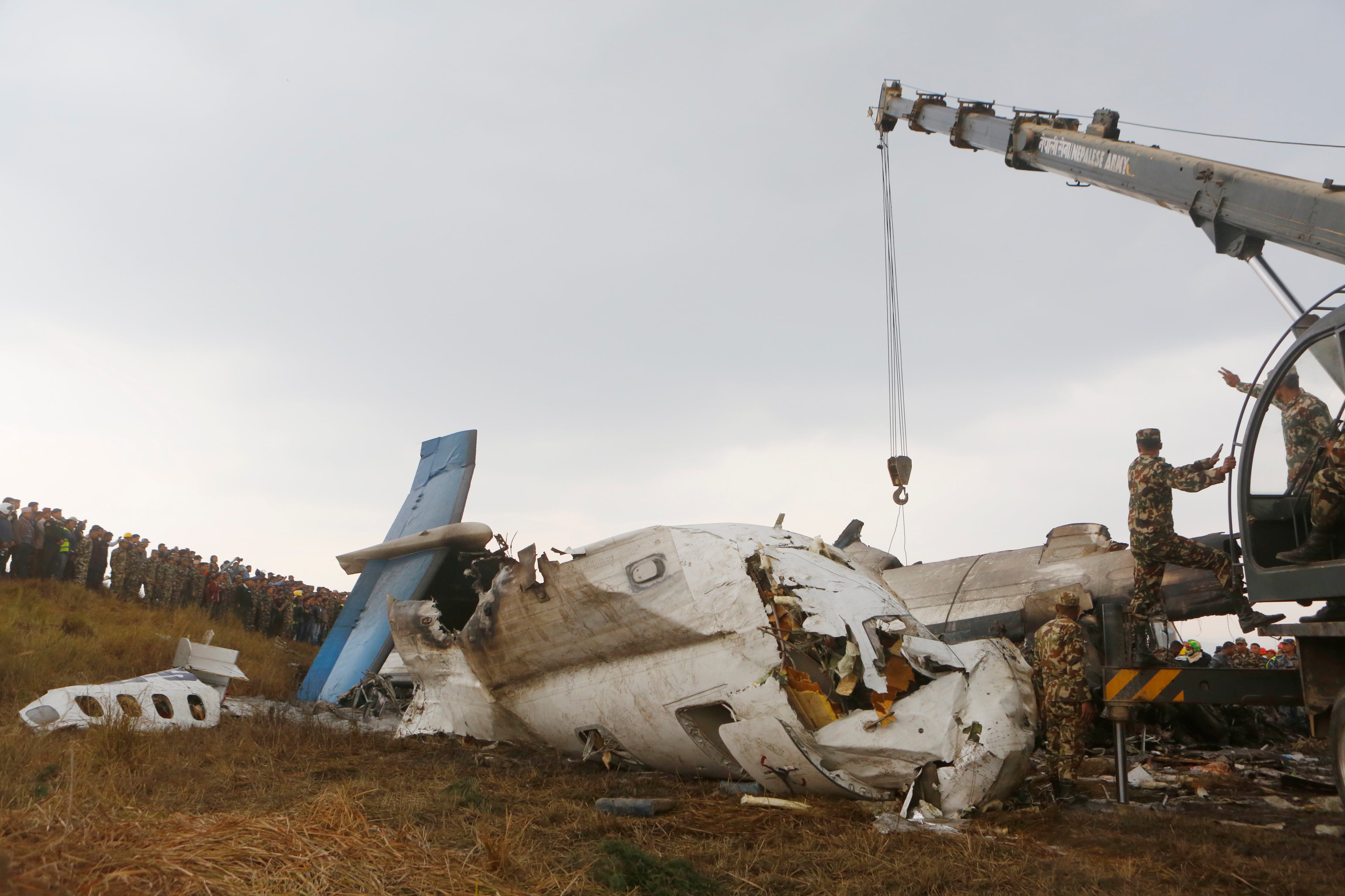 Nepalese army soldiers use machinery to lift the debris after a passenger plane from Bangladesh crashed at the airport in Kathmandu, Nepal, Monday, March 12, 2018. The passenger plane carrying 71 people from Bangladesh crashed and burst into flames as it landed Monday in Kathmandu, Nepal's capital, killing dozens of people, officials said. (AP Photo/Niranjan Shreshta)