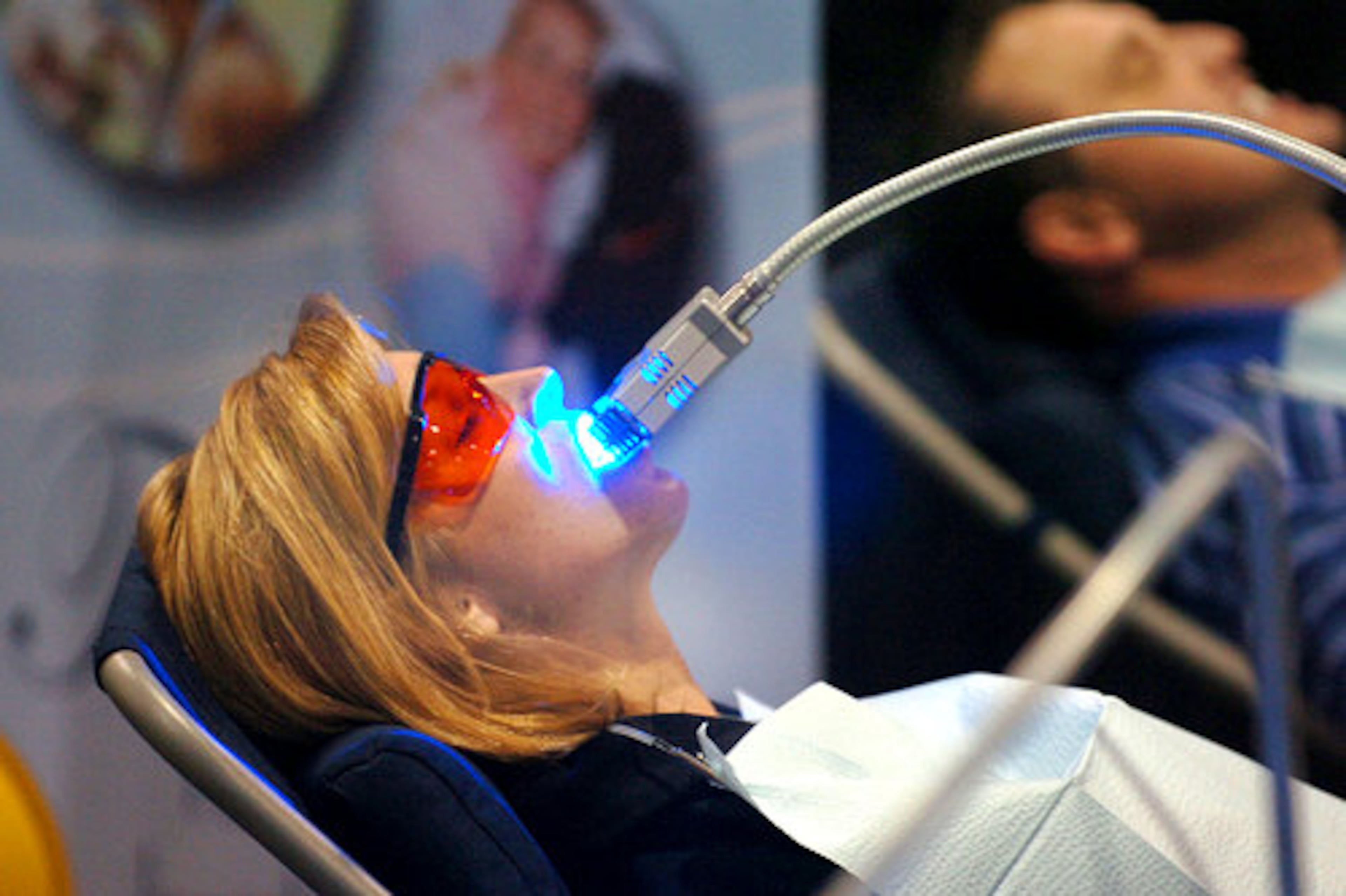 Genie Gilder, from Alpharetta, gets her teeth whitened at the Brite White Smiles booth.