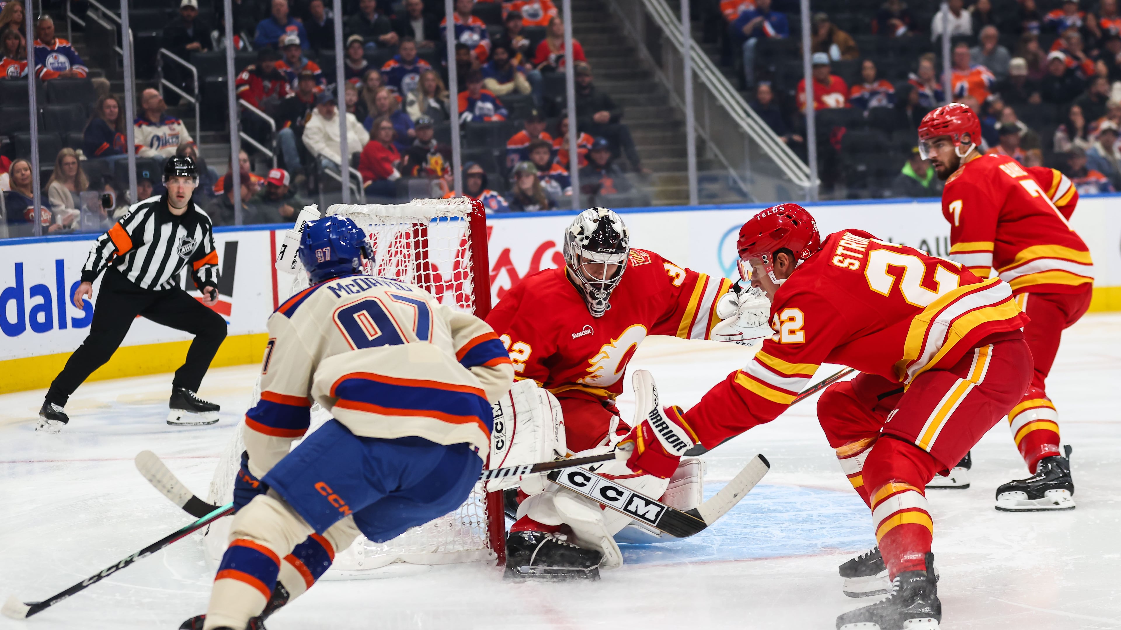 Edmonton Oilers' Connor McDavid, left, looks for an opportunity against Calgary Flames goaltender Dustin Wolf, center, during the second period of an NHL hockey game in Edmonton, Alberta, Wednesday, Oct. 28, 2026. (Codie McLachlan/The Canadian Press via AP)