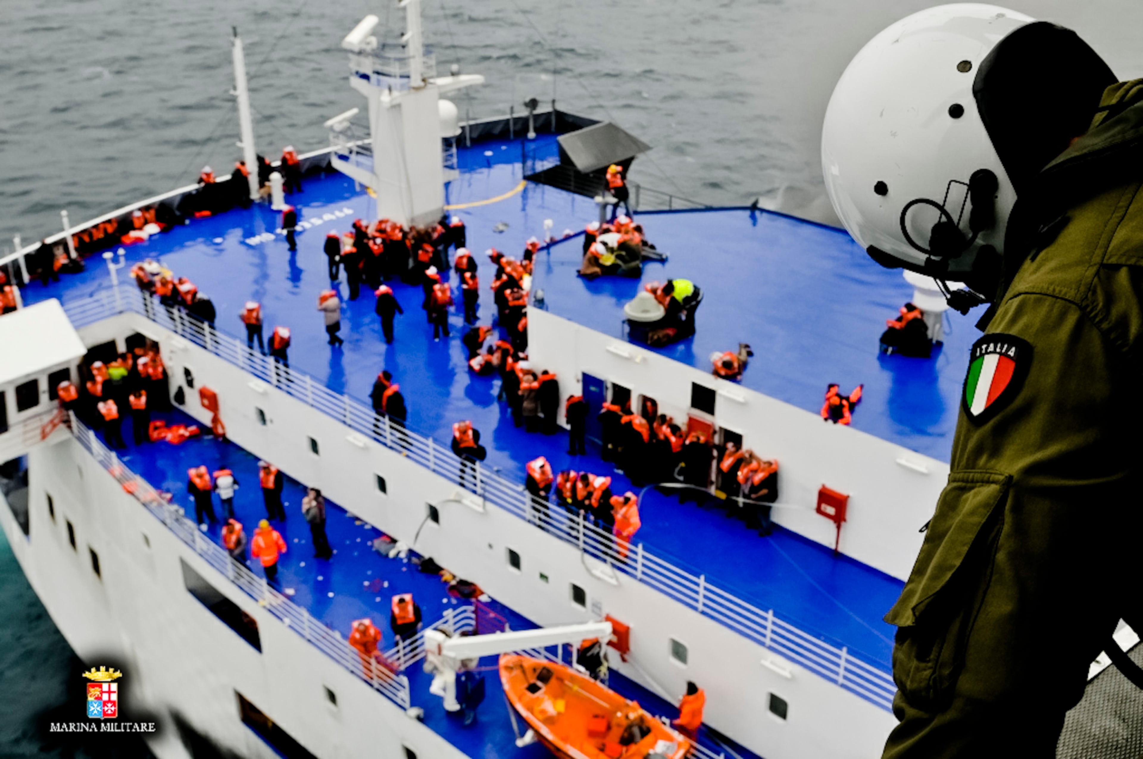 In this image released by the Italian Navy, passengers and crew are seen on the deck of the Italian-flagged ferry Norman Atlantic as it is approached by a rescue helicopter after it caught fire in the Adriatic Sea, Sunday, Dec. 28, 2014. Italian and Greek rescue crews battled gale-force winds and massive waves as they struggled Sunday to evacuate hundreds of people from a ferry on fire and adrift in the channel between Italy and Albania. At least one person died and two were injured. The fire broke out before dawn Sunday on a car deck of the Italian-flagged Norman Atlantic, traveling from the western Greek port of Patras to the Italian port of Ancona on the Adriatic, with 422 passengers and 56 crew members on board. (AP Photo/Italian Navy)