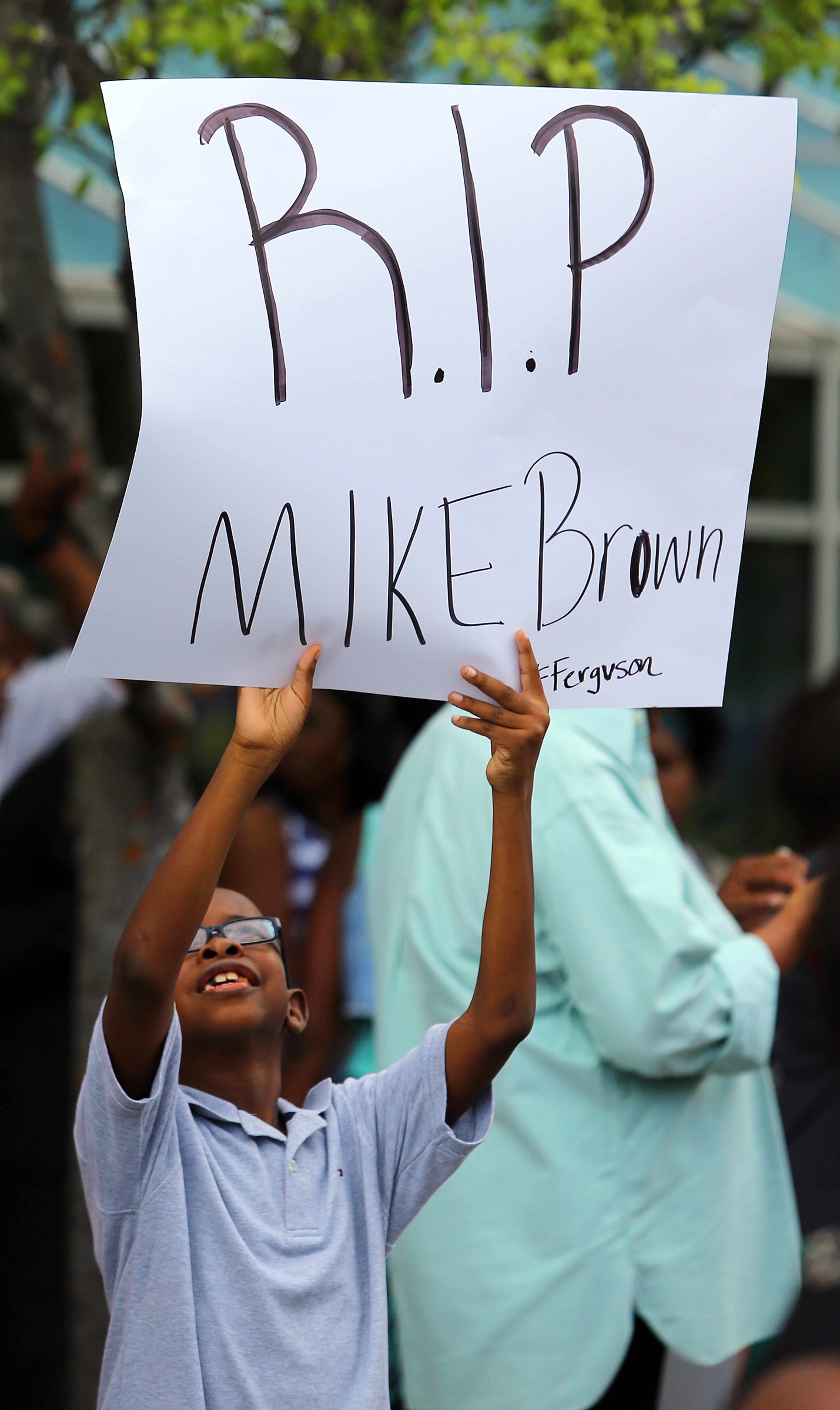 081814 Atlanta: Brian Hunter, 9, College Park, holds a sign during a rally for Mike Brown and Ferguson outside the CNN Center on Monday, August 18, 2014, in Atlanta. CURTIS COMPTON / CCOMPTON@AJC.COM