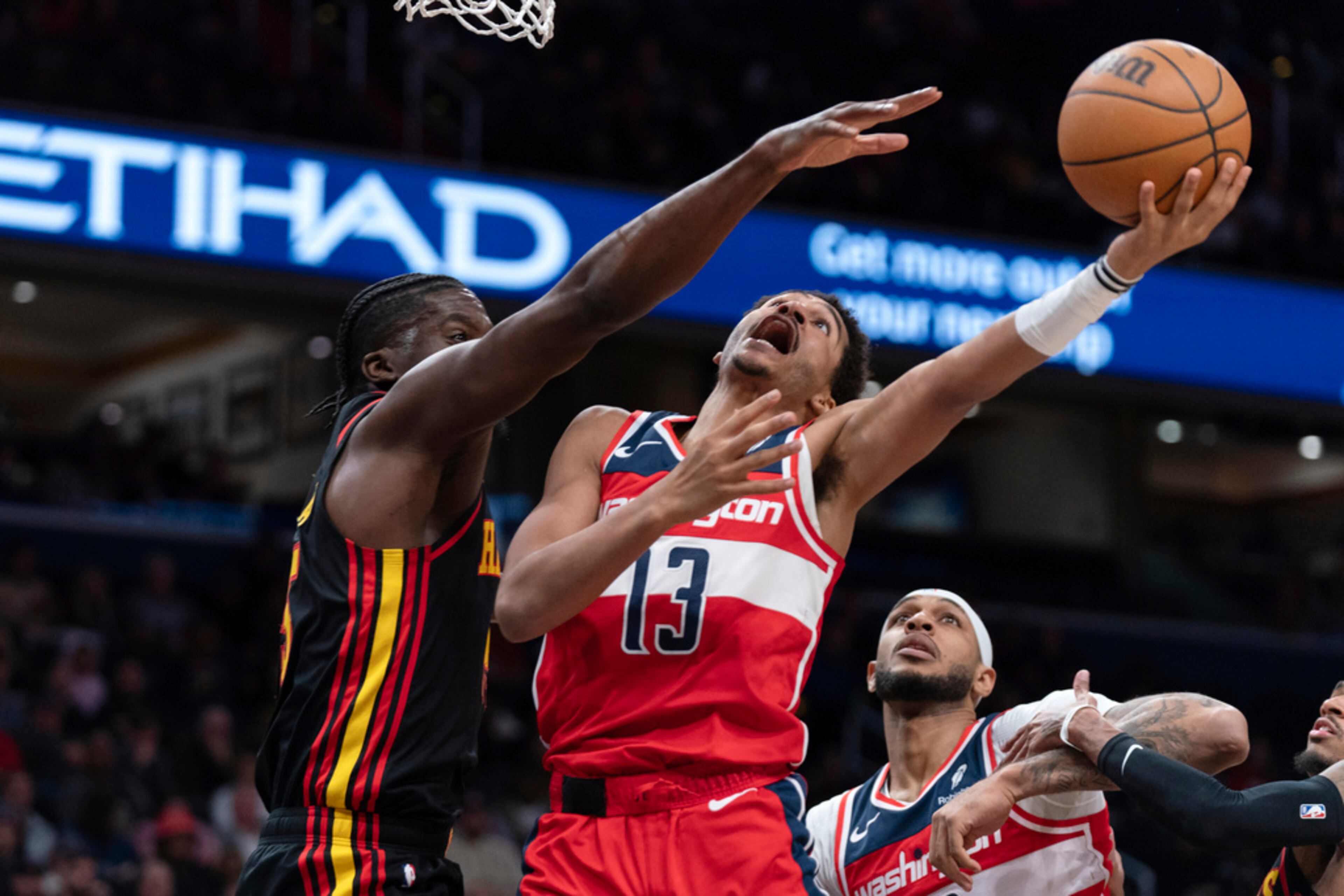 Washington Wizards' Jordan Poole (13) goes to the basket as Atlanta Hawks' Clint Capela, left, tries to block during the first half of an NBA basketball game Sunday, Dec. 31, 2023, in Washington. (AP Photo/Jose Luis Magana)