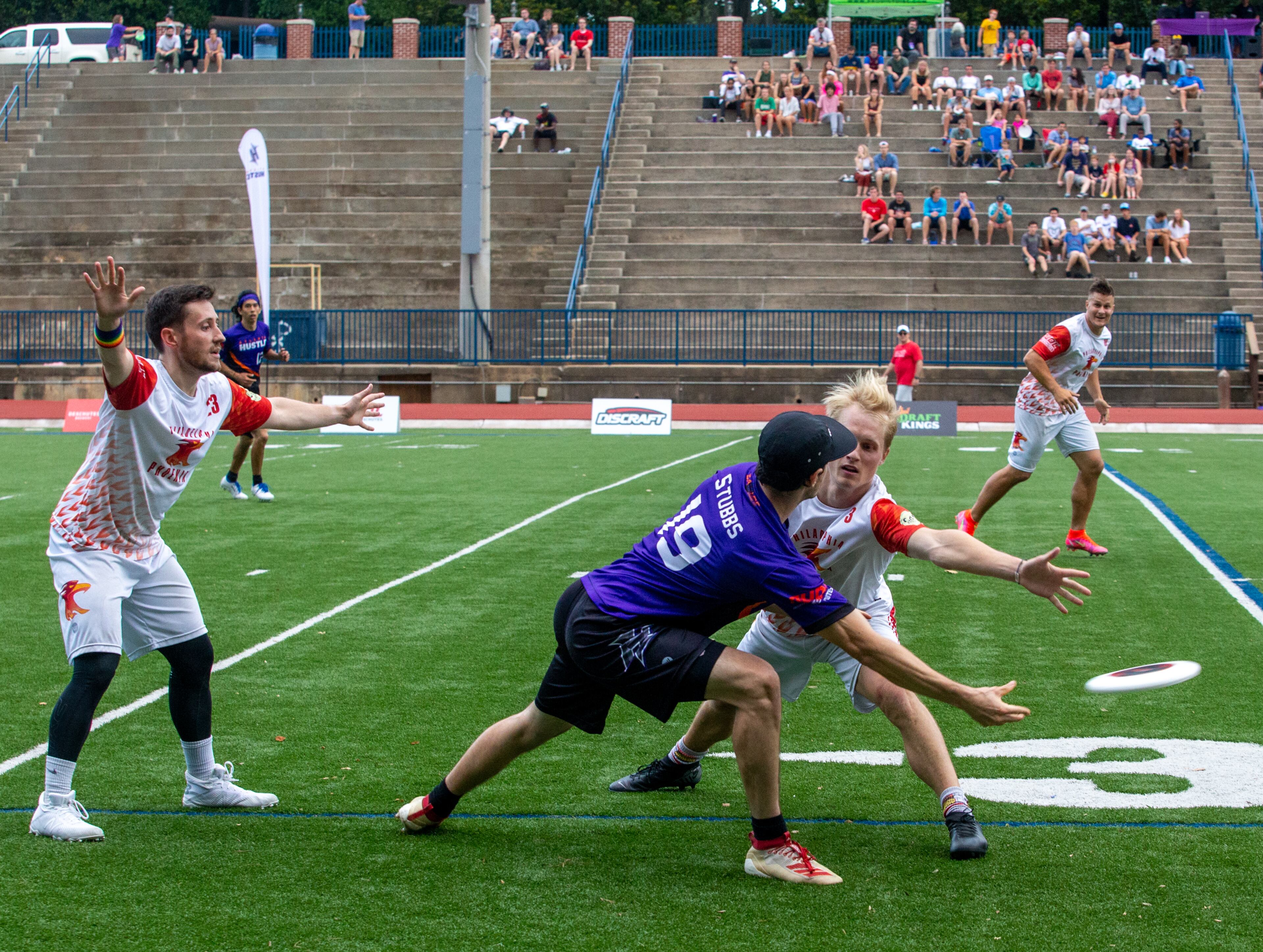 John Stubbs (center), #19, a player for the Hustle, Atlanta's American Ultimate Disc League team, passes around Philadelphia at St. Pius X High School Field on Saturday, June 26, 2021. Atlanta won the game 24-17. (Jenni Girtman for The Atlanta Journal-Constitution)