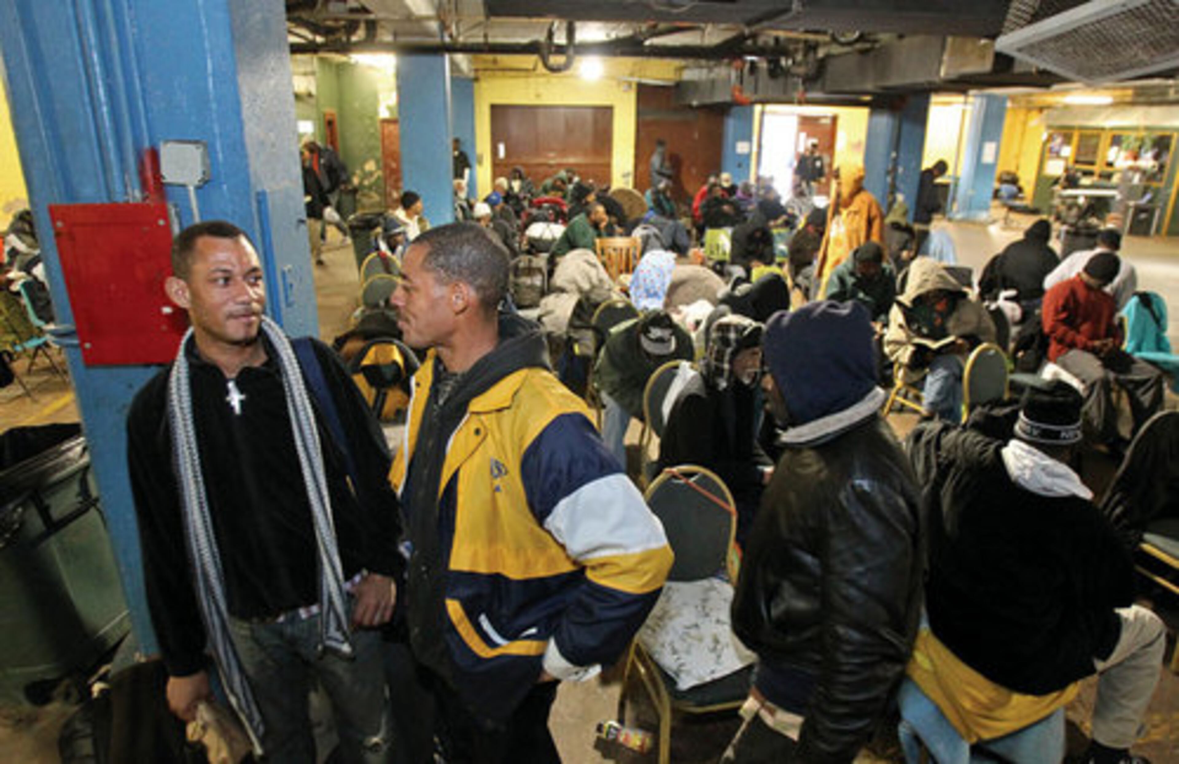 Sheldon Pinder, left, and Aaron Bowie, center (in yellow) chat after lunch. Six months ago Bowie was living at the shelter. Now he and Pinder are moving into their own apartment. Bowie has a job as a waiter at a local restaurant. Bowie and Pinder came to the shelter Wednesday for lunch and to get a furniture voucher for their new apartment.