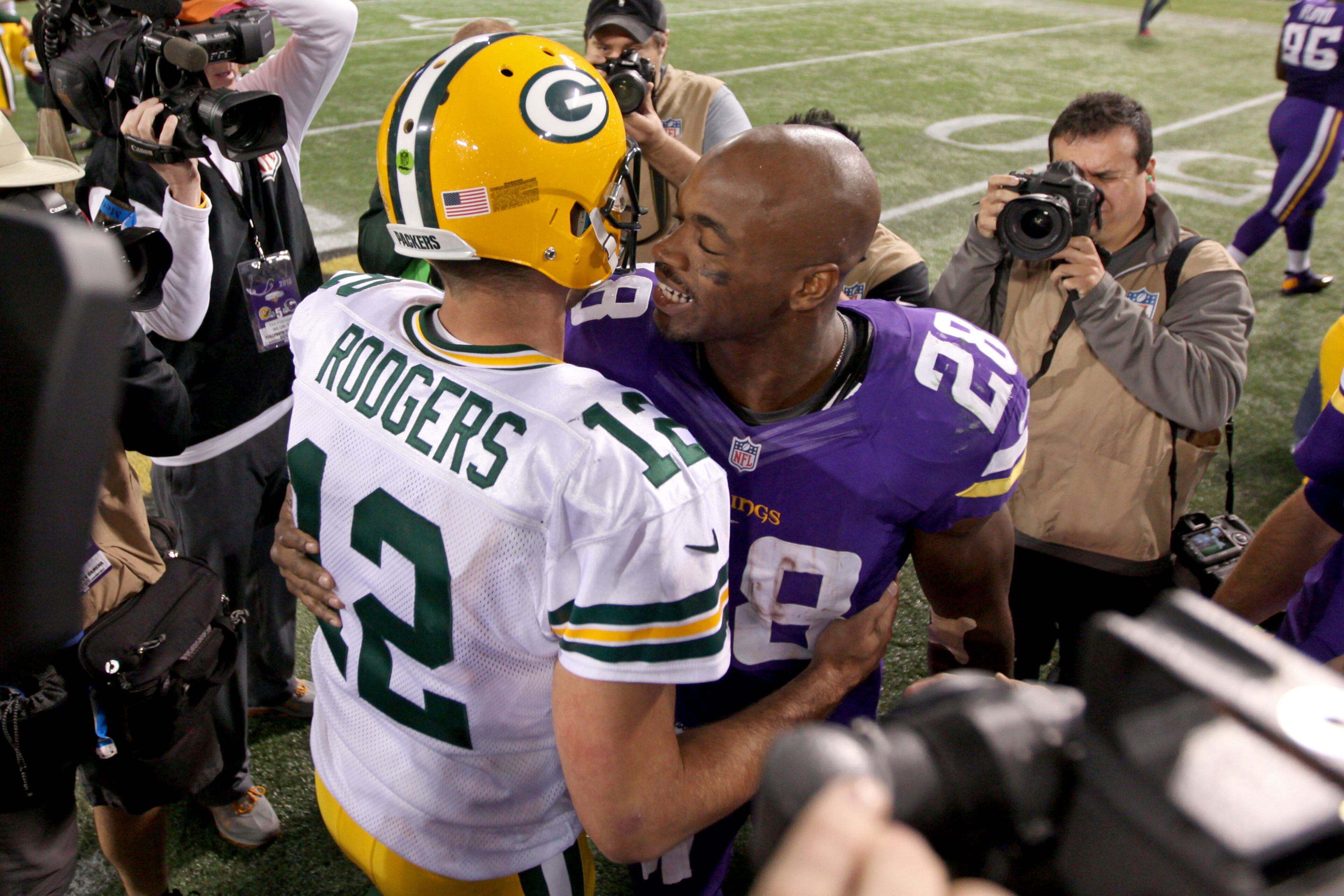 Minnesota Vikings running back Adrian Peterson (28) talks with Green Bay Packers quarterback Aaron Rodgers (12) following the game at Mall of America Field at H.H.H. Metrodome. The Green Bay Packers defeated the Minnesota Vikings 44-31. Mandatory Credit: Brace Hemmelgarn-USA TODAY Sports