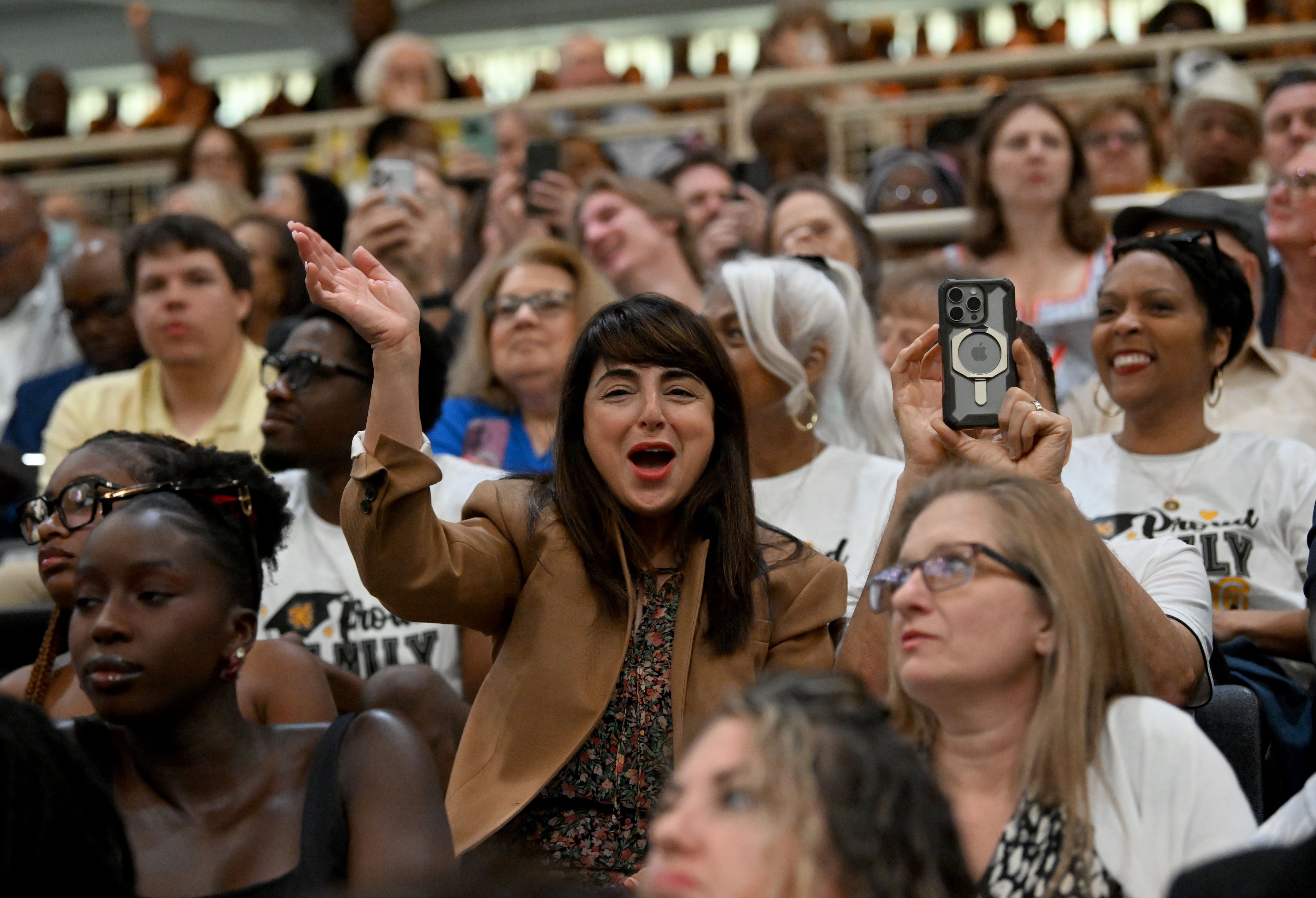 Family and friends spot their graduates during during the ceremony. (Hyosub Shin/AJC)