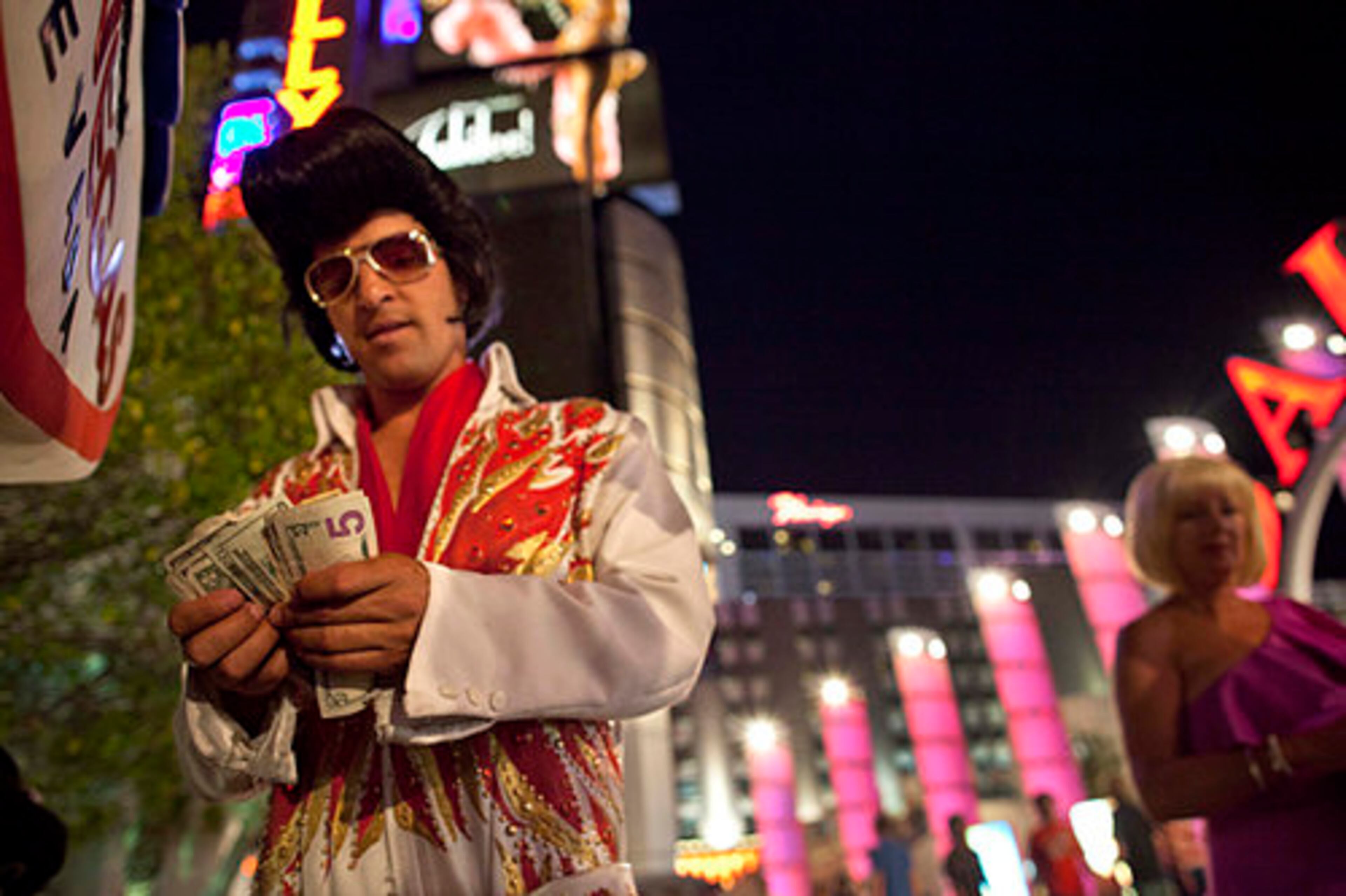 While impersonating Elvis along The Strip, Rodrigo Gonsalez takes a moment to count the night's tip earnings.