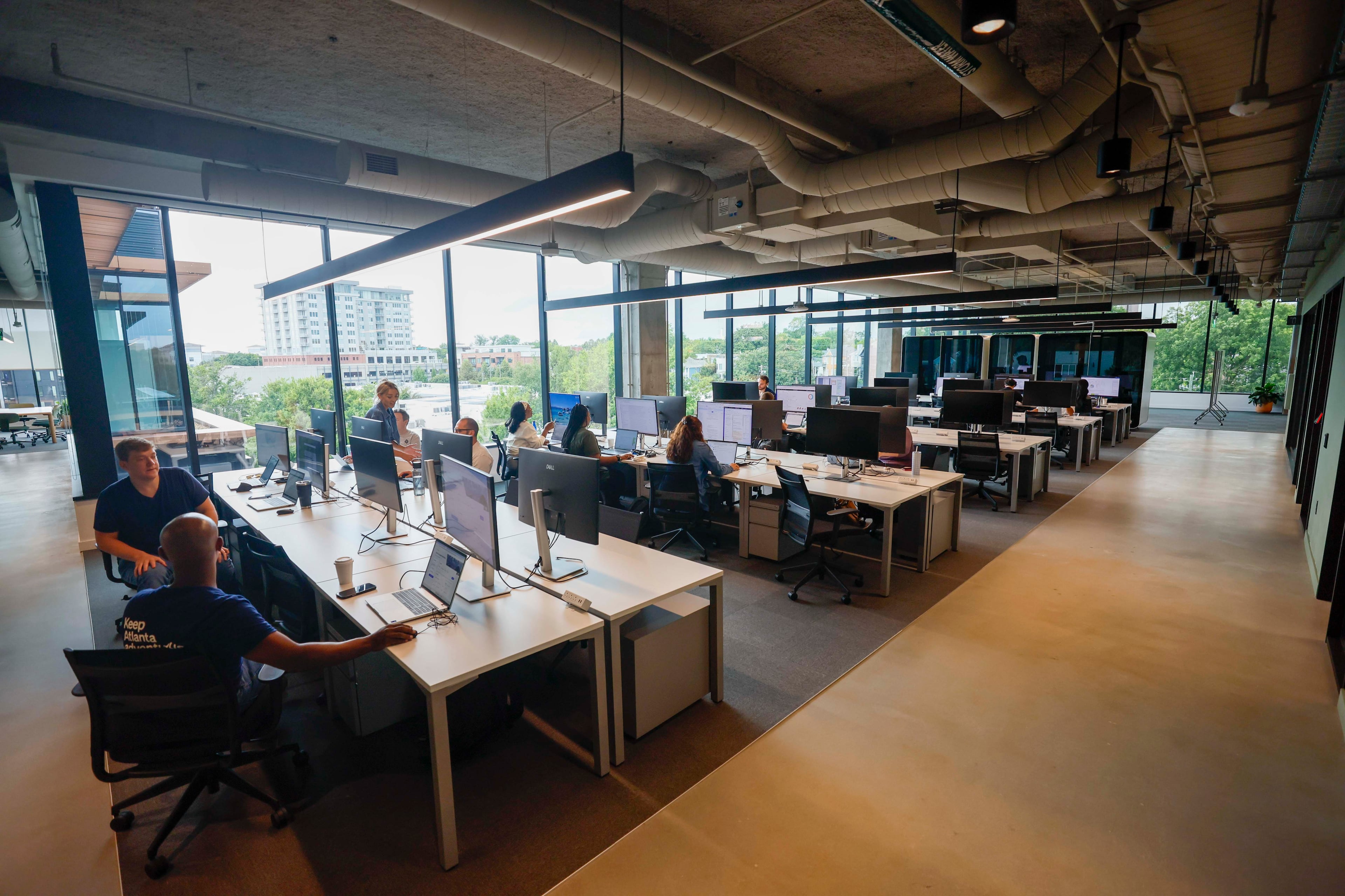 Rivian employees work at desks at their new East Coast headquarters in Atlanta. (Miguel Martinez/AJC)