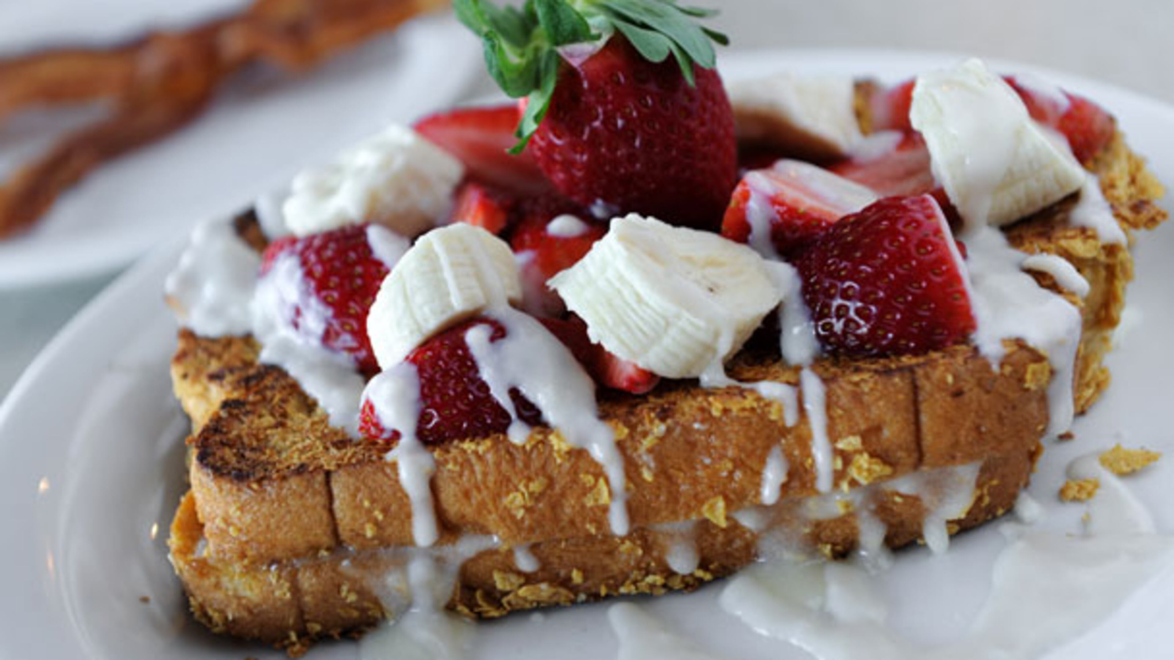 Firstlook at Reville Cafe in Marietta on Friday January 18, 2013. FOOD: Mystic Stuffed French Toast- sliced Hawaiian bread stuffed with cream cheese filling, coated with Kellogg's corn flakes, grilled then topped with strawberry and bananas, drizzled with vanilla rum sauce.