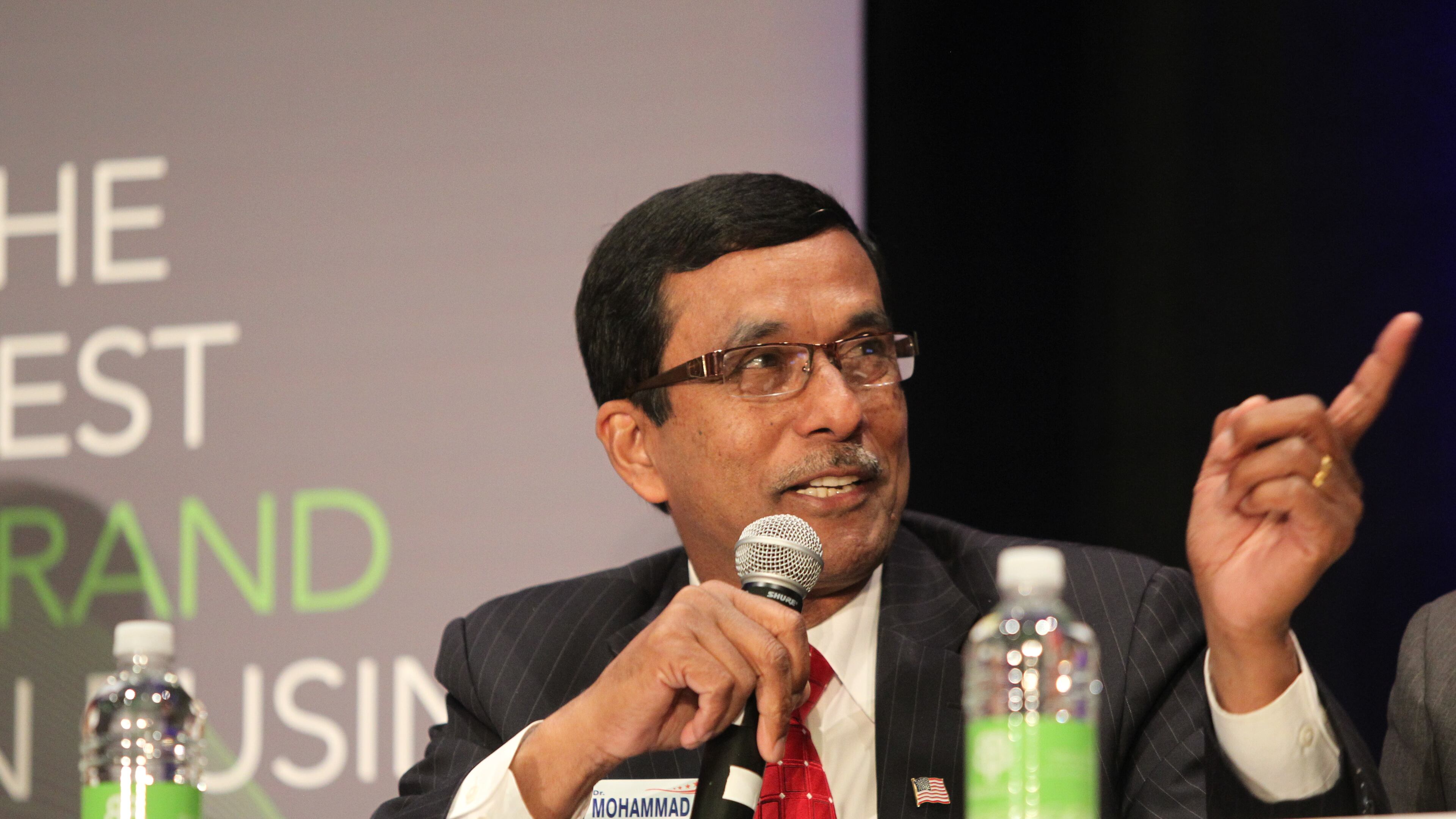 Mohammad Ali Bhuiyan speaks to the crowd of attendees at a Sixth District debate in Marietta in March. Henry Taylor, henry.taylor@ajc.com