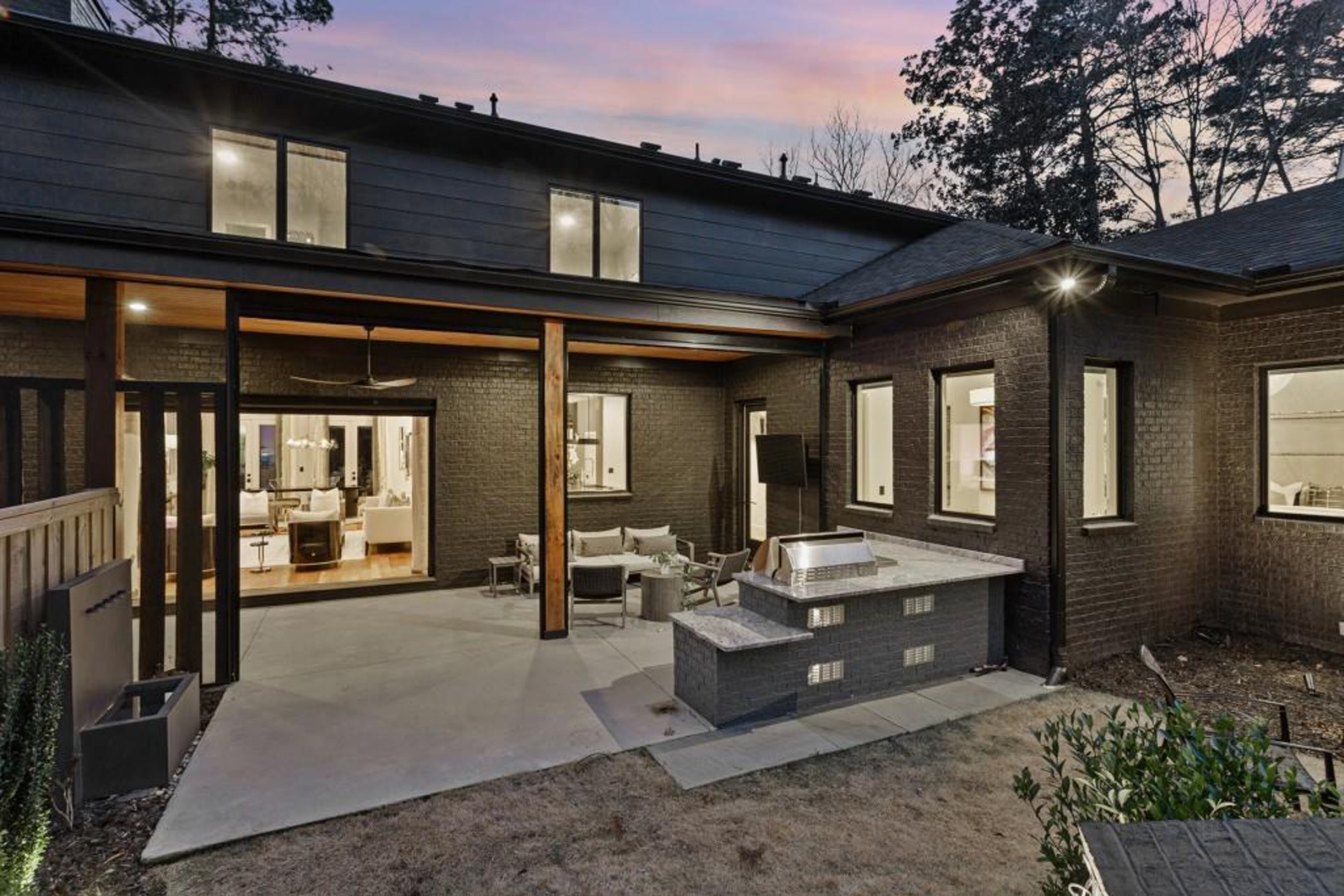 Covered back porch features automated screens, outdoor kitchen, and separate dining area.