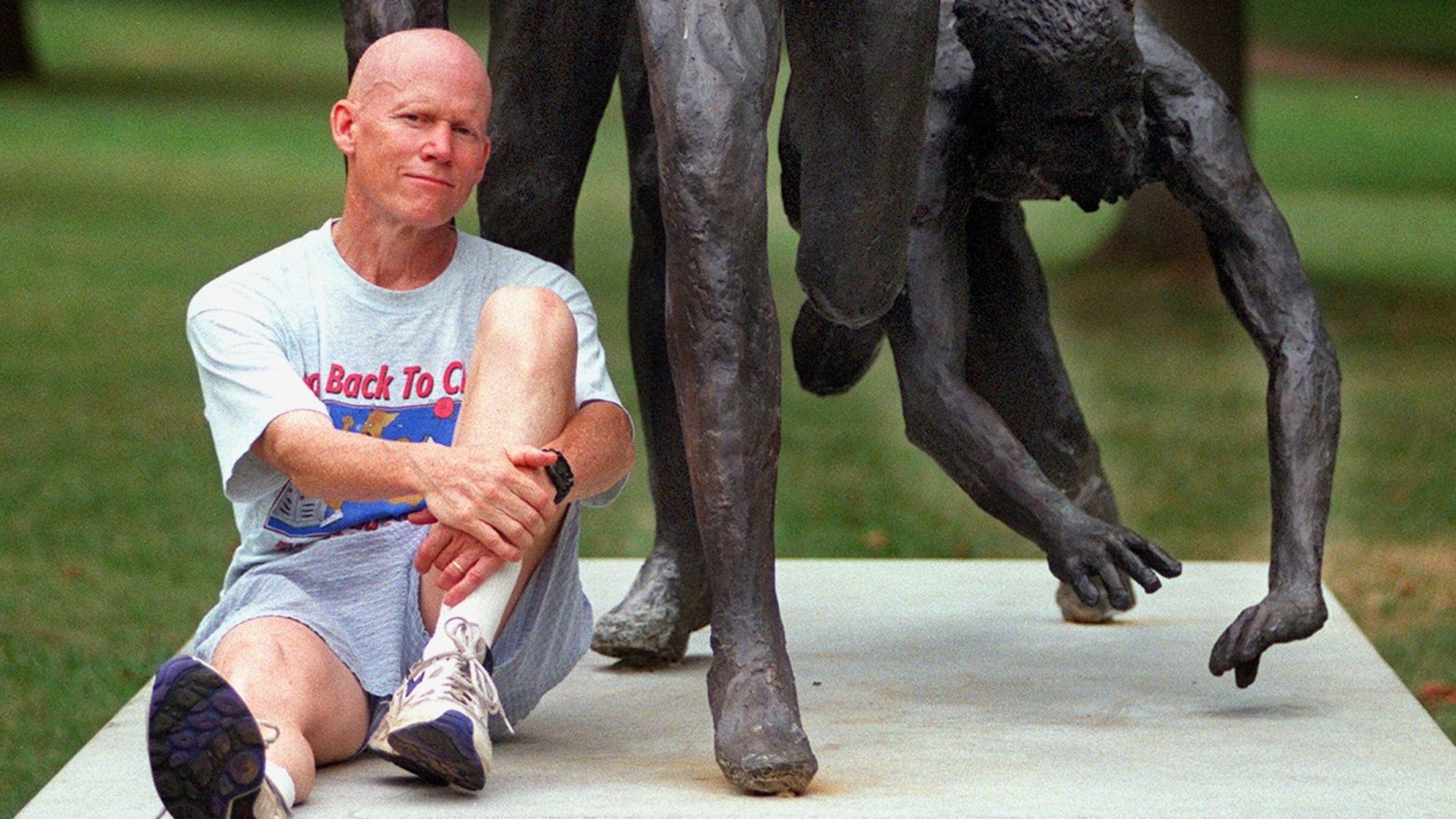 Dick Buerkle posed for this 1998 AJC photo after becoming the oldest winner of the masters division of the Peachtree Road Race. Buerkle sat at the base of "The Last Meter" sculpture in Piedmont Park, which depicts the conclusion of the final of the 5,000 meters at the 1976 Olympics, a race that he qualified for but did not reach the finals. (AJC file photo by Alicia Hansen)