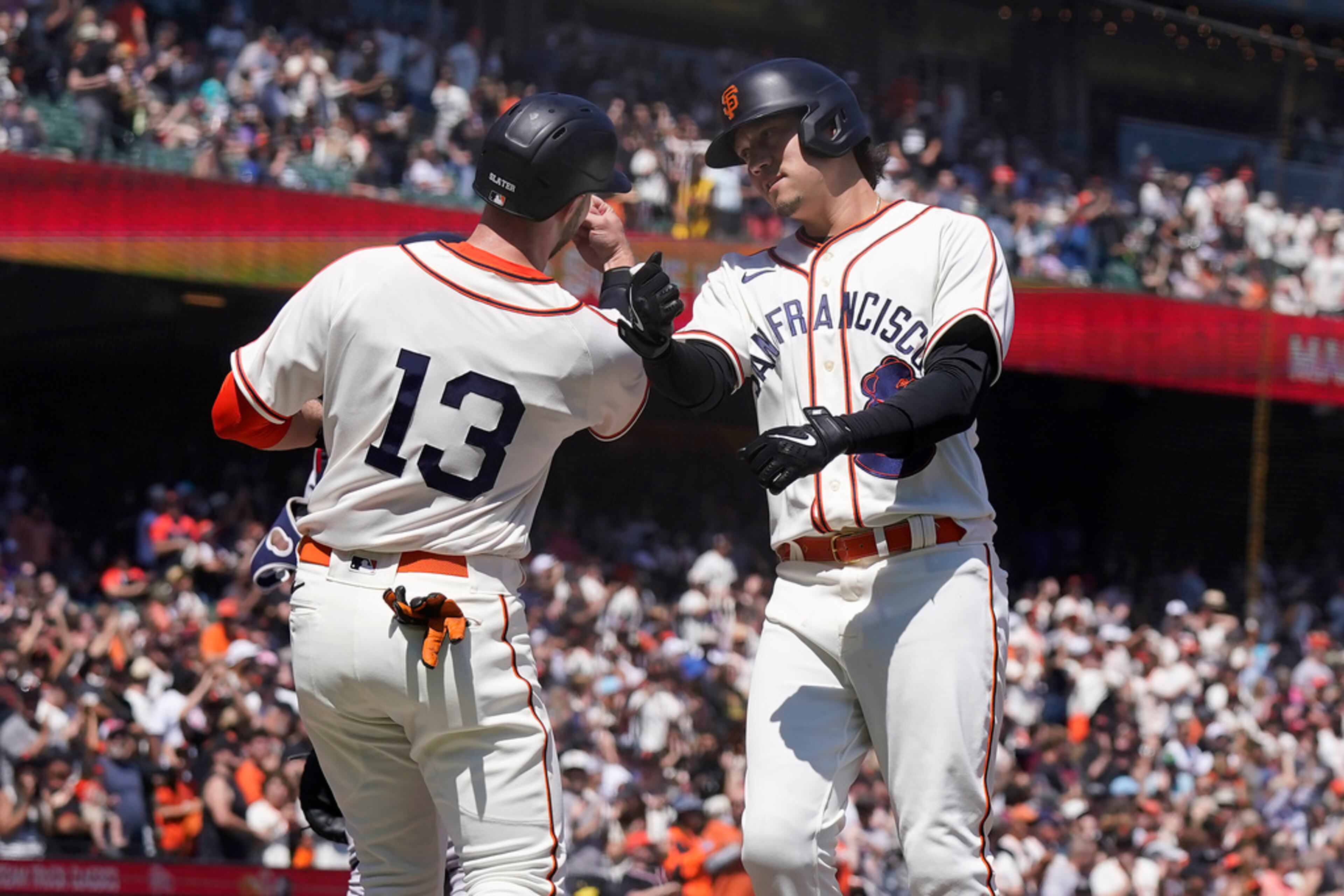 San Francisco Giants' Wilmer Flores, right, celebrates after hitting a two-run home run that scored Austin Slater (13) during the third inning of a baseball game against the Atlanta Braves in San Francisco, Saturday, Aug. 26, 2023. (AP Photo/Jeff Chiu)