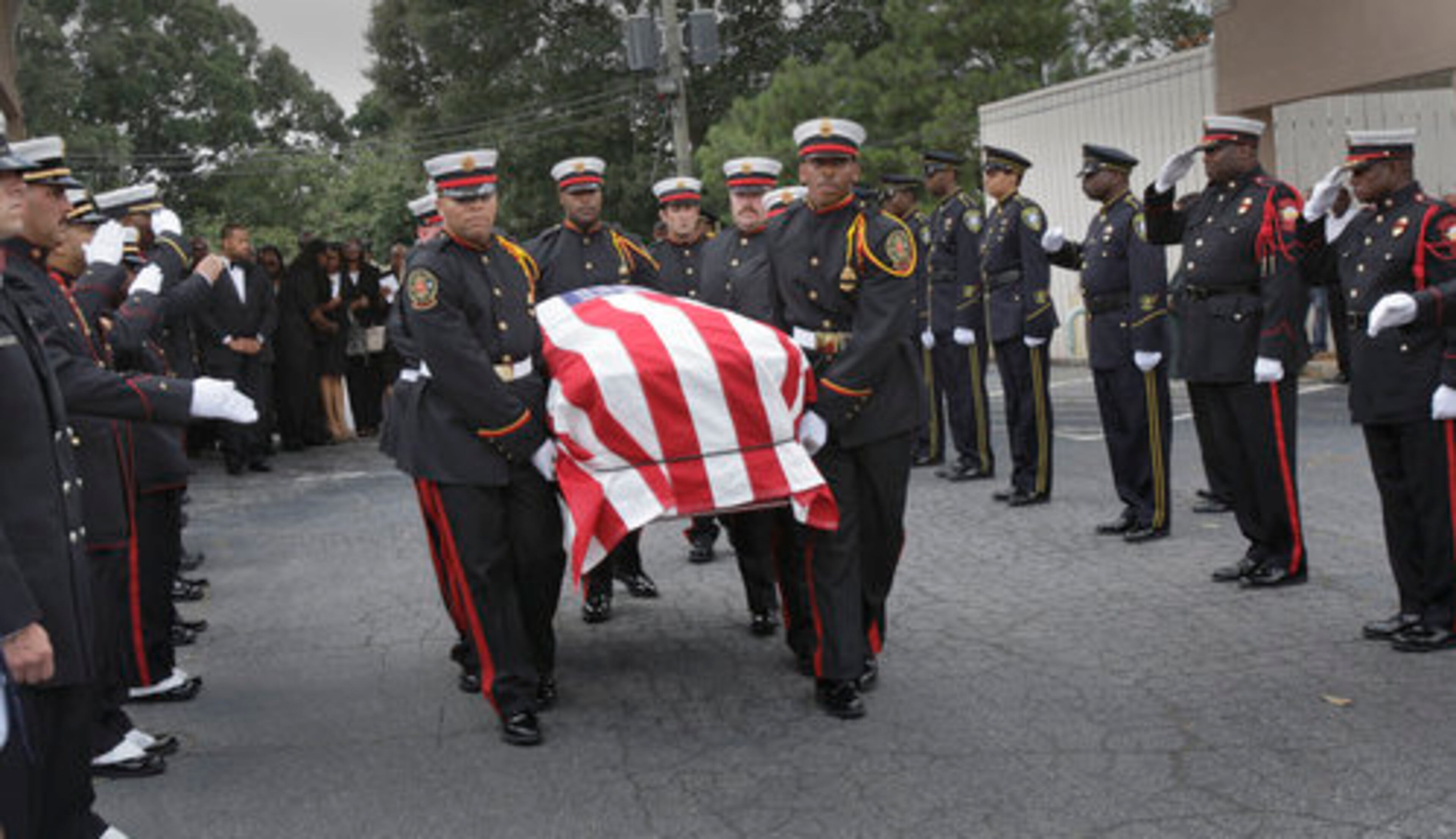 Pall bearers carry the casket to a fire truck, which carried it to the cemetery.