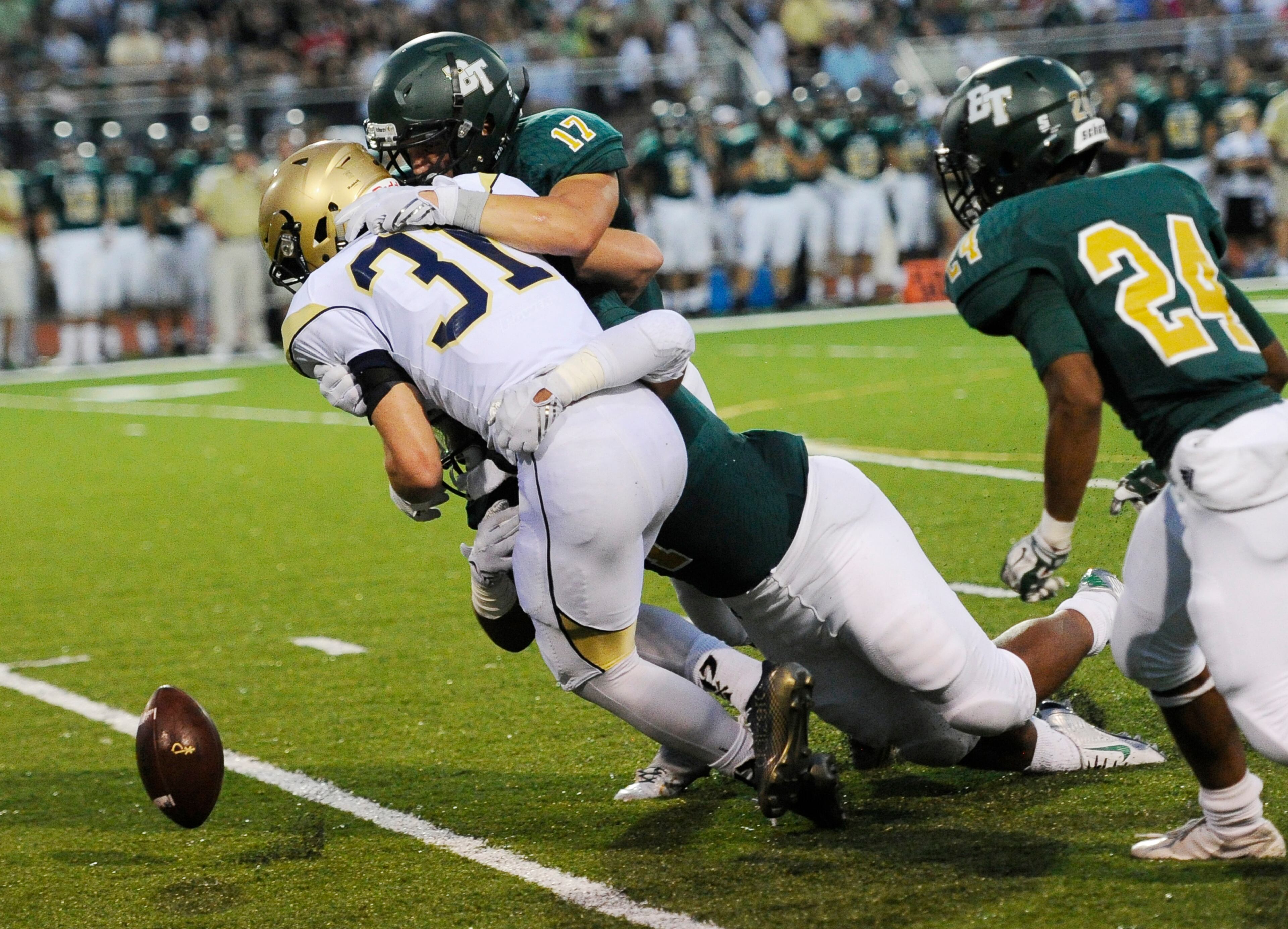 Blessed Trinity linebacker Logan Craighead and defensive tackle Shane Parton force a fumble by St. Pius RB Ransom Klinger (31) during the first half of a high school football game, Friday, Aug. 28, 2015, in Roswell (Special/John Amis)