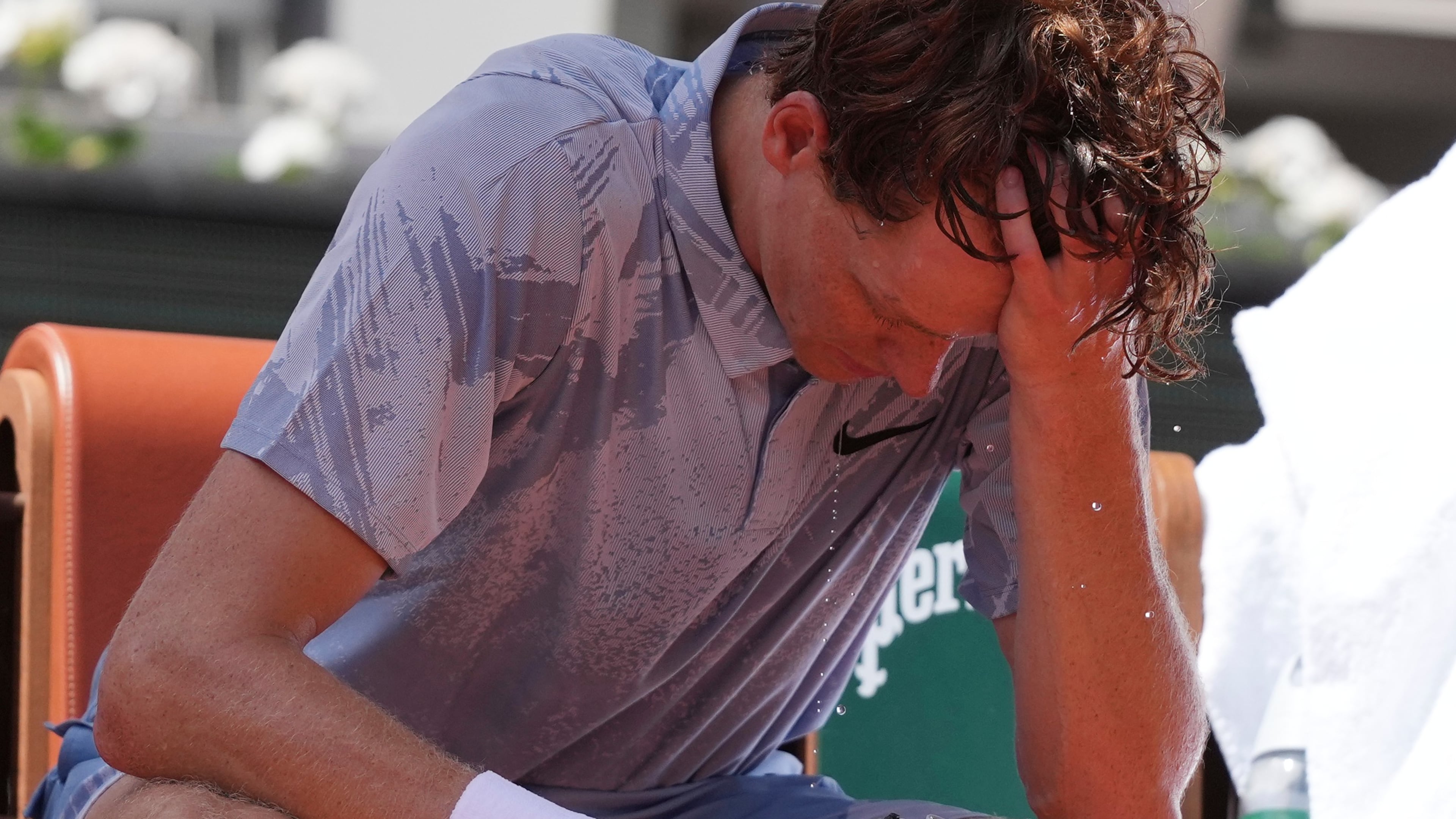 Jannik Sinner of Italy reacts as he cools himself with the water during a break at the second round men's singles tennis match against Juan Manuel Cerundolo of Argentina at the French Open tennis tournament in Paris, Thursday, May 28, 2026, as temperature rises up to 33 C (91 F). (AP Photo/Thibault Camus)