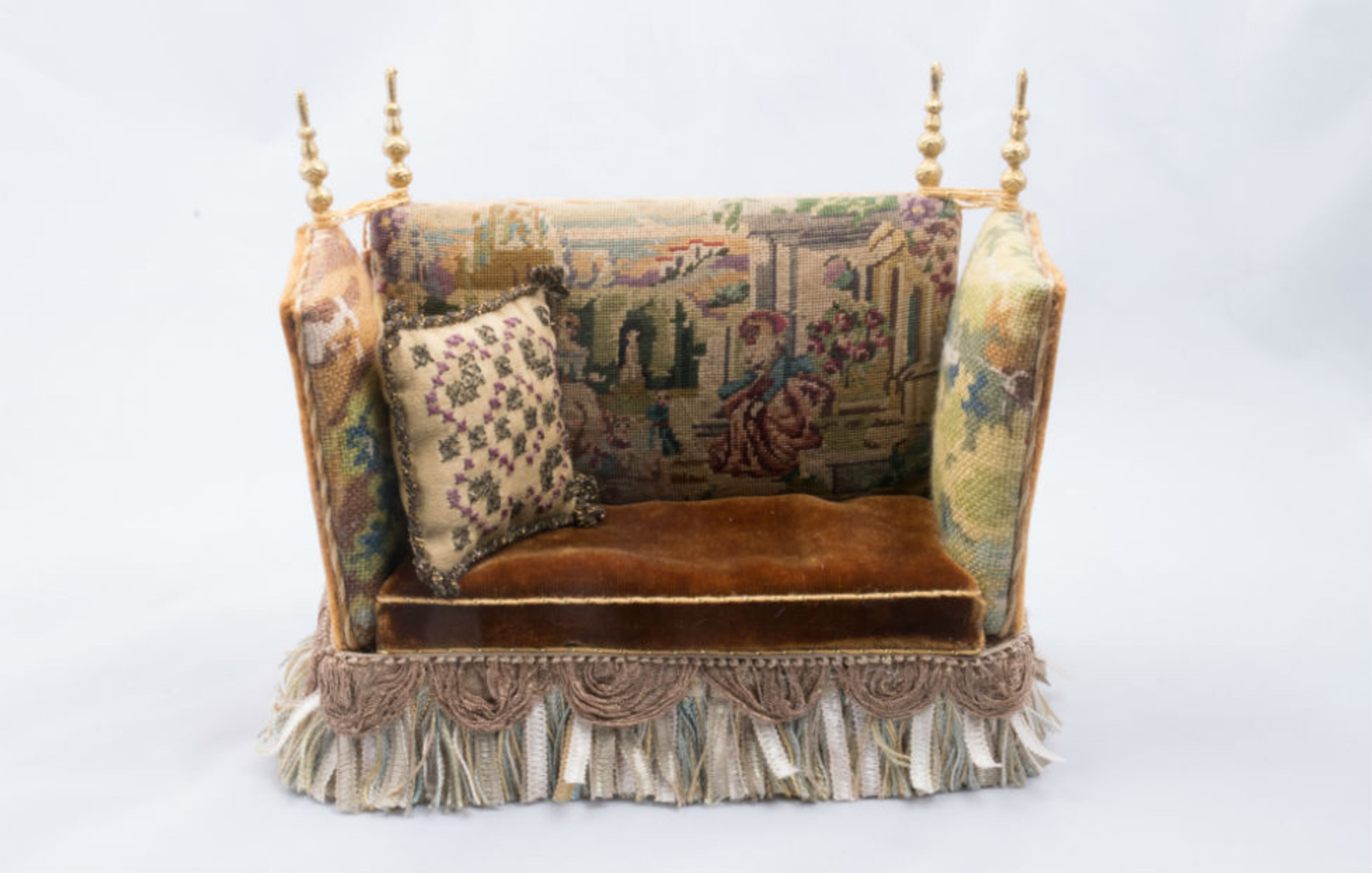 The room also includes a couch upholstered in custom needlework …