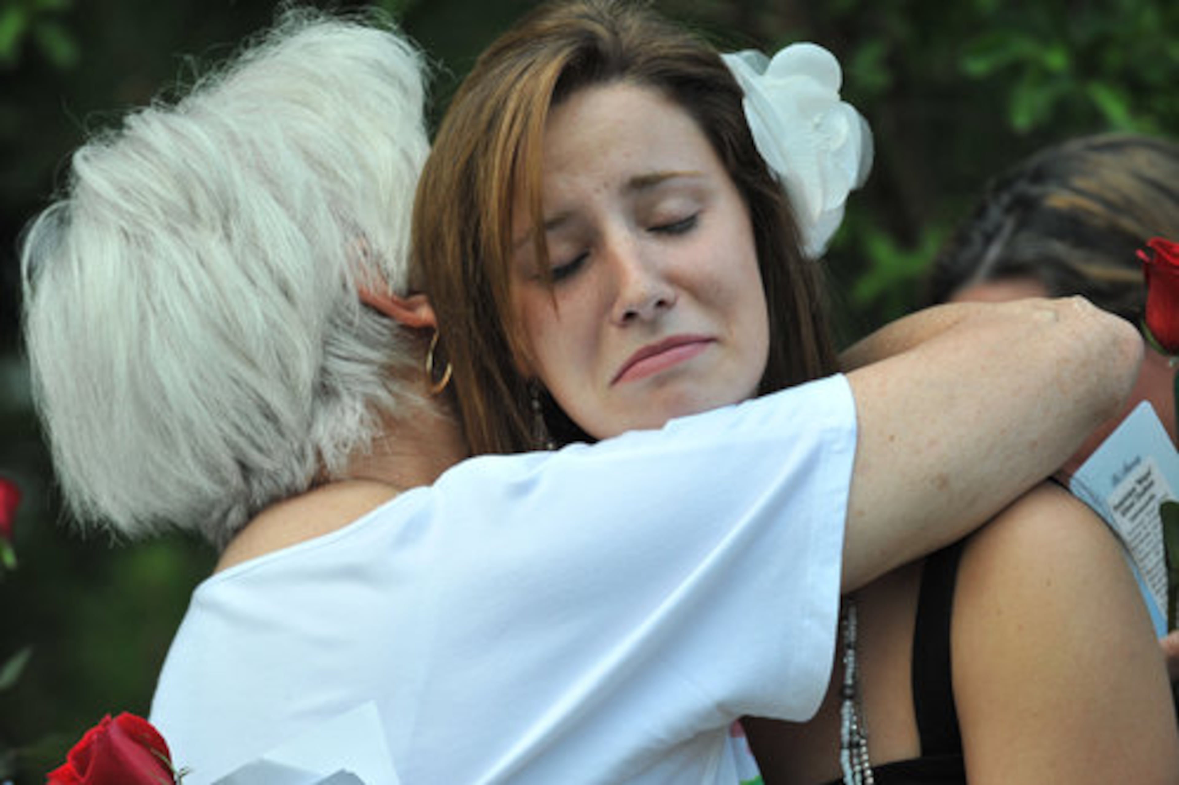 Alex Page (right), 19, the oldest daughter of Nique Leili, gets a hug from her grandmother and Nique's mother Harriett Garrett during the candlelight vigil.