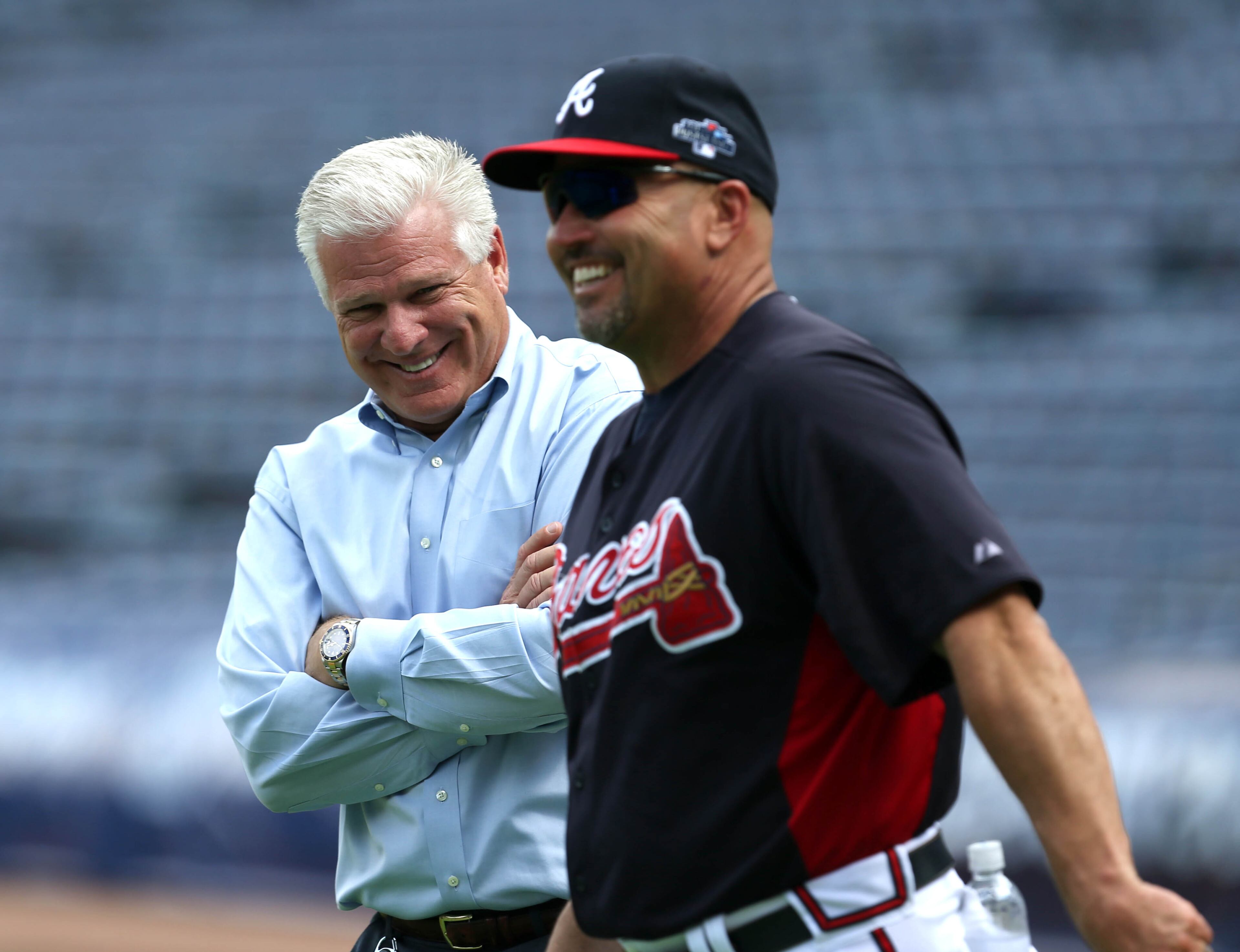 Atlanta Braves general manager Frank Wren, left, laughs with manager Fredi Gonzalez as they watch batting practice in preparation for their NL Division Series against the Los Angeles Dodgers at Turner Field in Atlanta, Ga., October 2, 2013. The Atlanta Braves host the Los Angeles Dodgers in game 1 of the NL Division Series Thursday October 3, 2013 at 8:37pm.