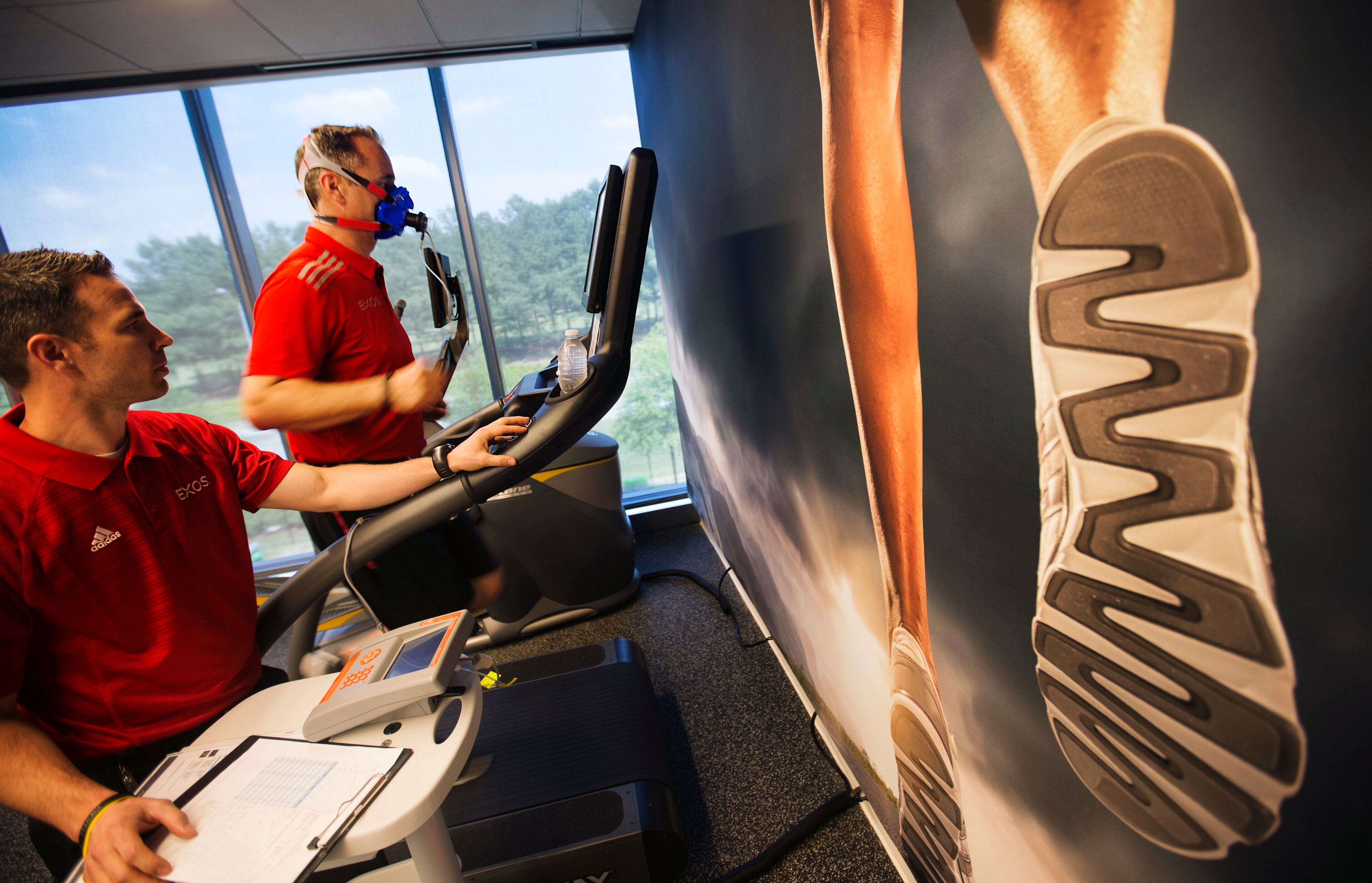 Russ Orr, right, director of performance, runs on a treadmill while hooked up to a breathing apparatus as David Talley, performance nutritionist, looks on in the fitness center during the opening of Porsche's new North American headquarters, dubbed the Porsche Experience Center, Thursday, May 7, 2015, in Atlanta. The facility features a human performance fitness center, classic car gallery and restoration center in addition to a driving simulator lab and fine-dining restaurant overlooking a driver development track. (AP Photo/David Goldman)