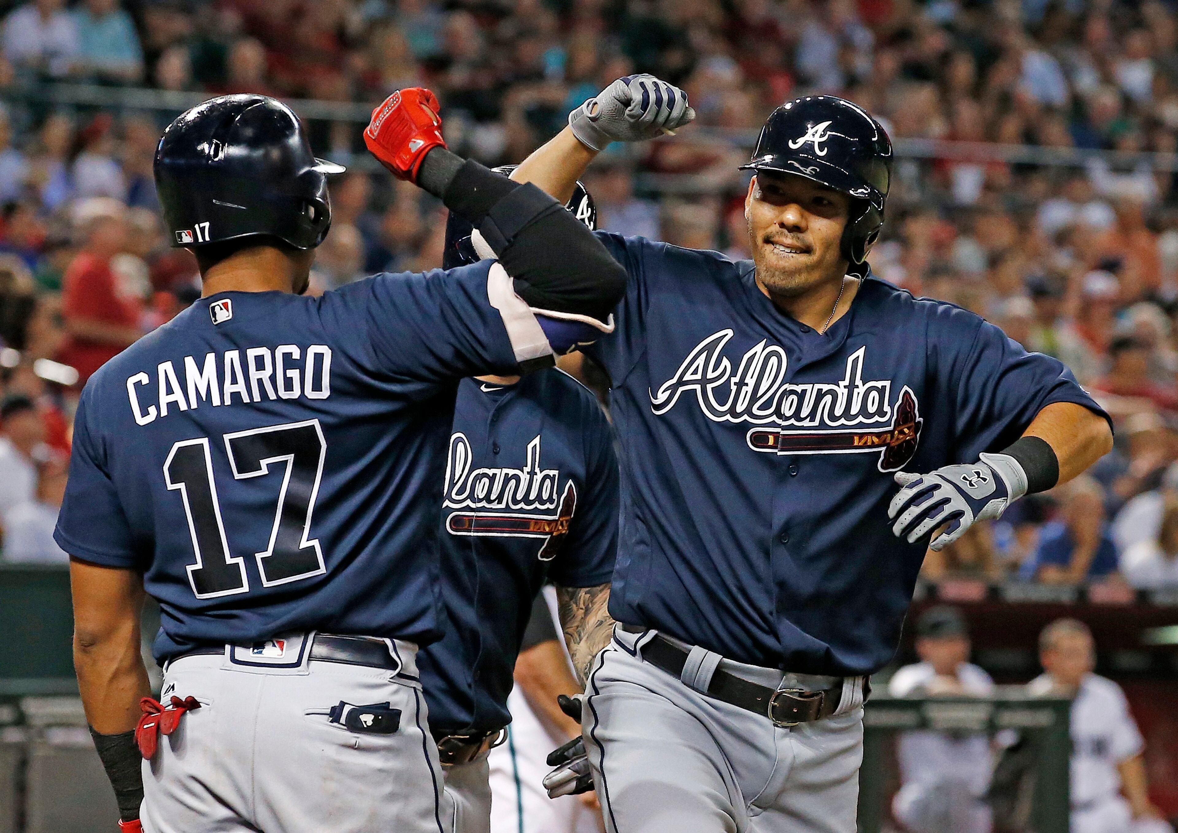 Atlanta Braves' Kurt Suzuki, right, celebrates his two-run home run against the Arizona Diamondbacks with Johan Camargo (17) during the seventh inning of a baseball game Tuesday, July 25, 2017, in Phoenix. (AP Photo/Ross D. Franklin)