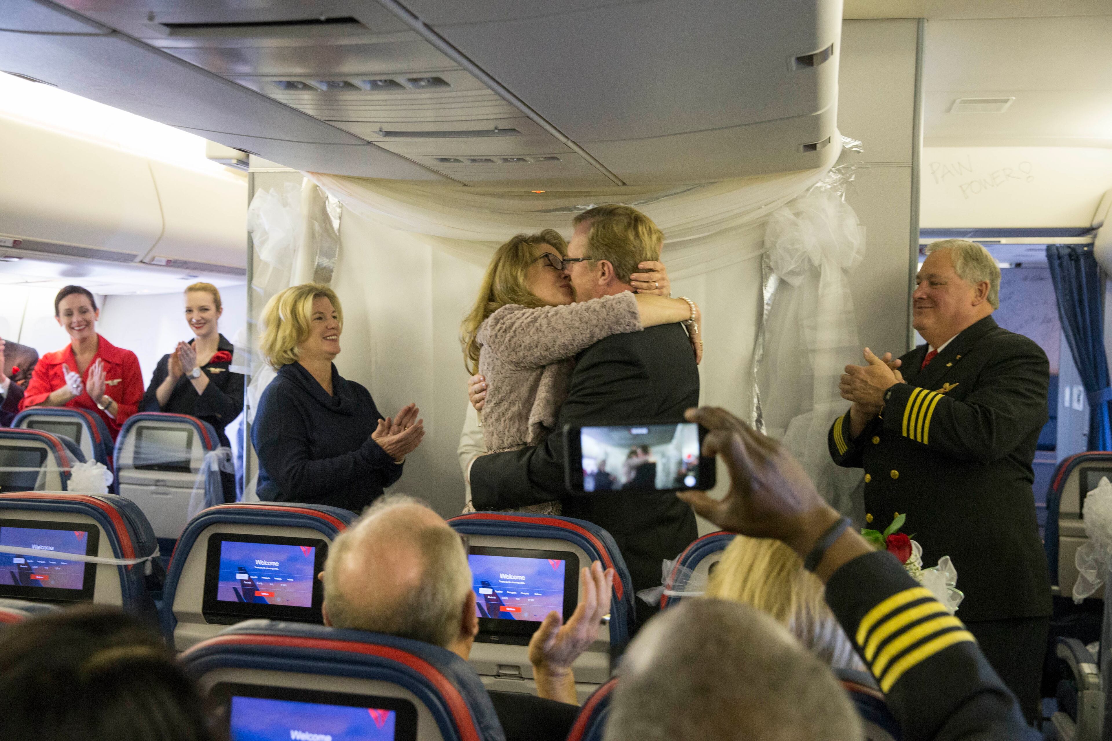 Delta flight attendant Holly Rick and Delta pilot Gene Peterson embrace after being united in marriage on the last flight of Delta's Boeing 747 airplane on January 3, 2018. Holly met Gene in 2009 while flying on the Delta 747. ALYSSA POINTER/ALYSSA.POINTER@AJC.COM