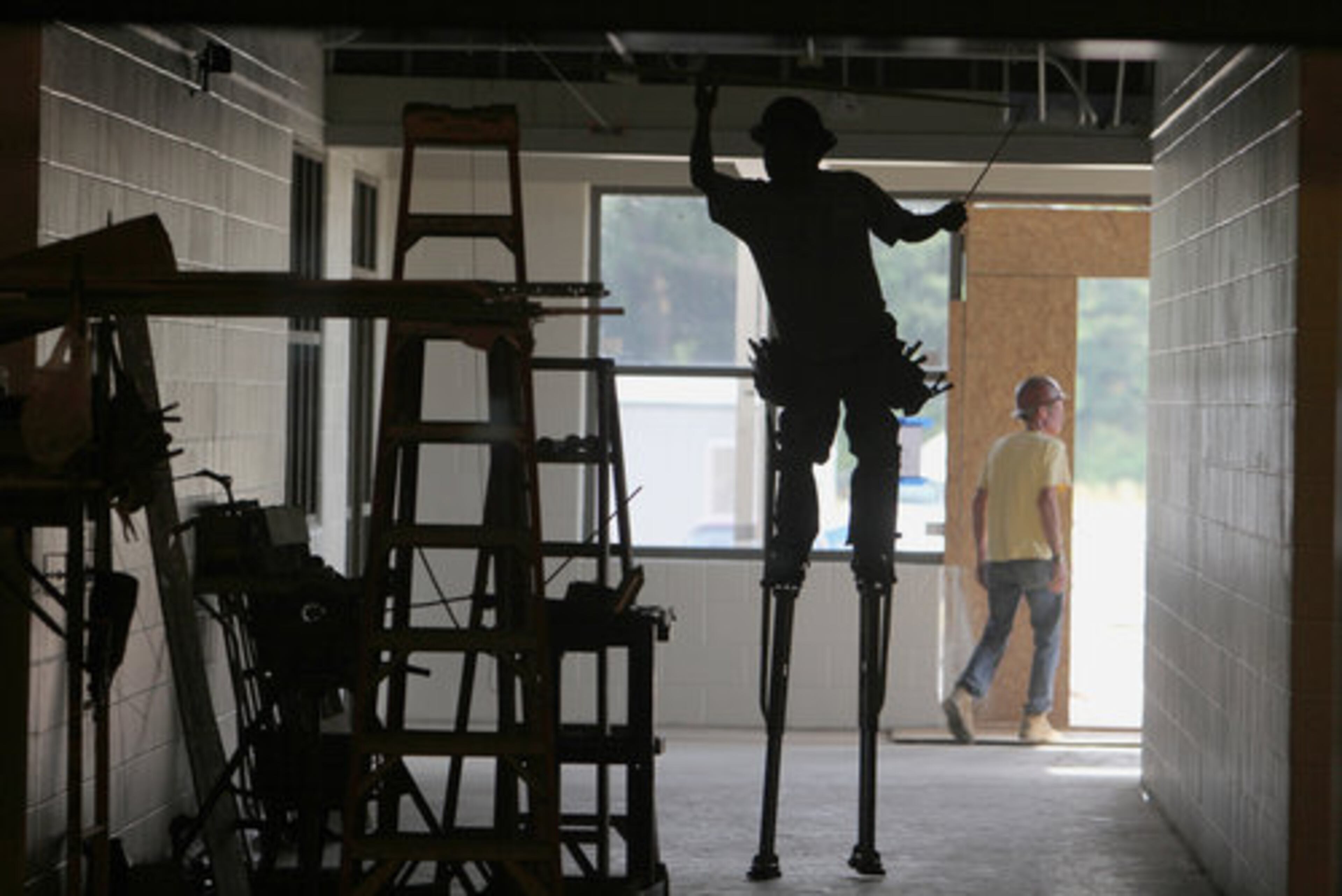 SCHOOL WORK--Evergreen construction and sub-contractor crews work on the ceiling, windows, painting and electrical inside the new elementary school that is scheduled to be completed in the fall. The new building will have 77 classrooms on about 38 acres of land. Cherokee County schools are moving forward with an ELOST vote in November. We take a look at this new elementary school in construction along Hunt Road in Acworth Wednesday, May 25, 2011.