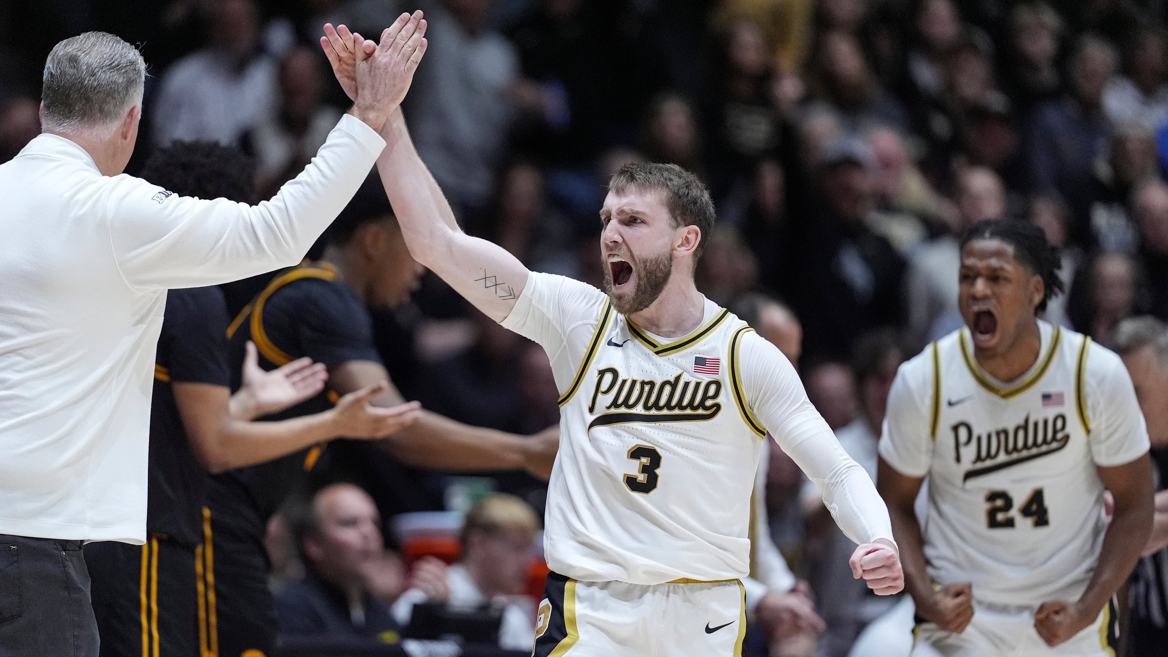 Purdue guard Braden Smith (3) high-fives head coach Matt Painter, left, after forcing a turnover against Iowa during the second half of an NCAA college basketball game in West Lafayette, Ind., Wednesday, Jan. 14, 2026. (AP Photo/Michael Conroy)